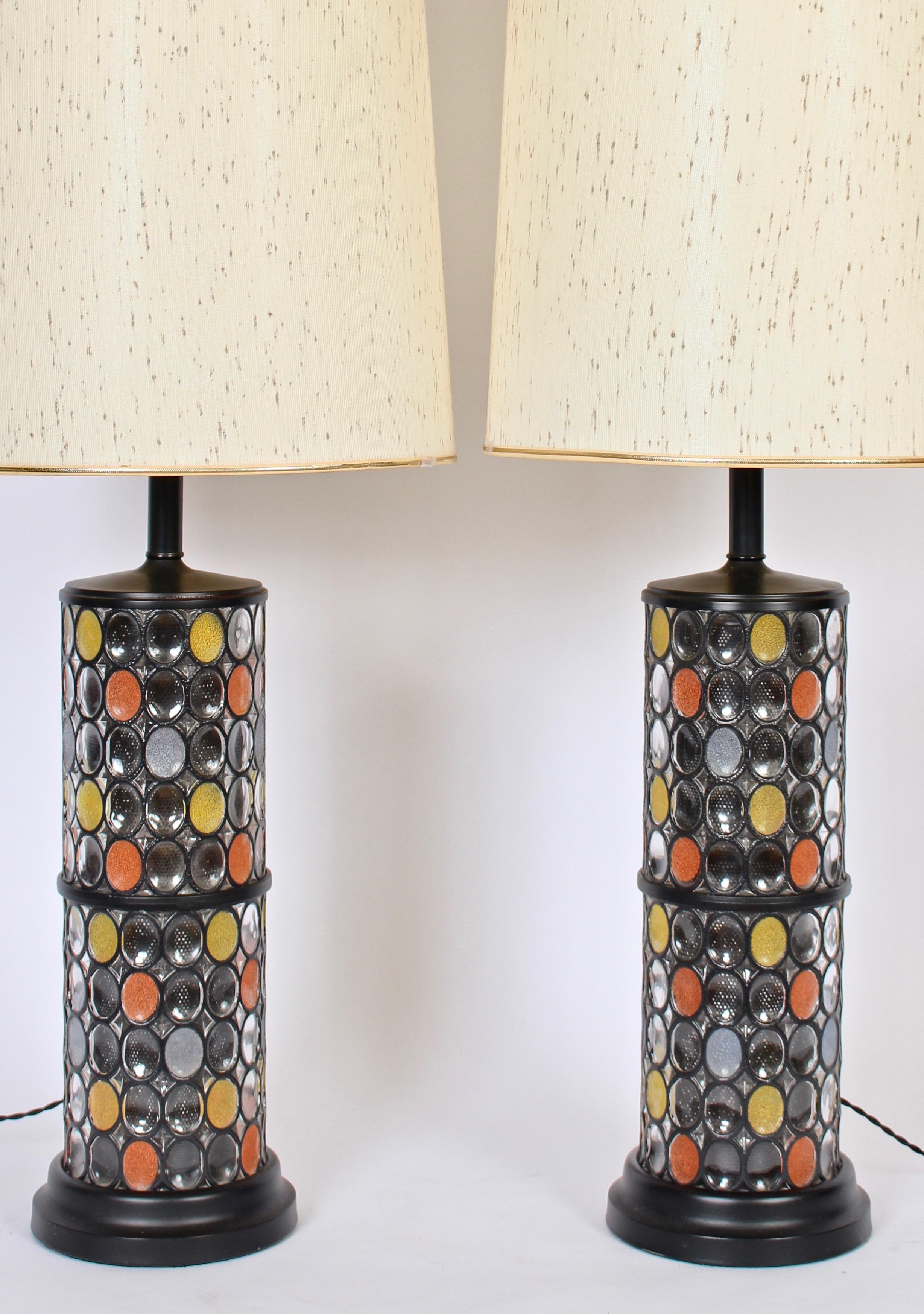 Substantial 3' H pair of black enameled metal and colorful glass table lamps in the manner of Higgins glass studio. Lamps feature a lantern form with interior cylindrical black screen insert. Surround detailed with clear and ovoid granulated glass