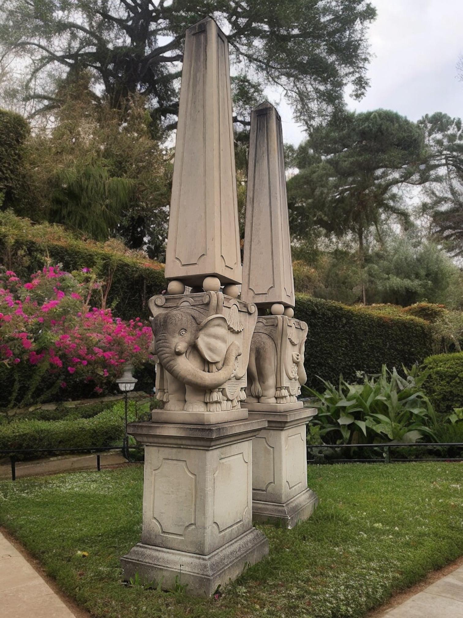 Pareja de elegantes obeliscos de piedra finamente tallados y decorados con guirnaldas de hojas, sobre una base cuadrada.
 Inspirada en la obra de Bernini  elefante en la Piazza della Minerva Roma.
Decoración intemporal para tu jardín o