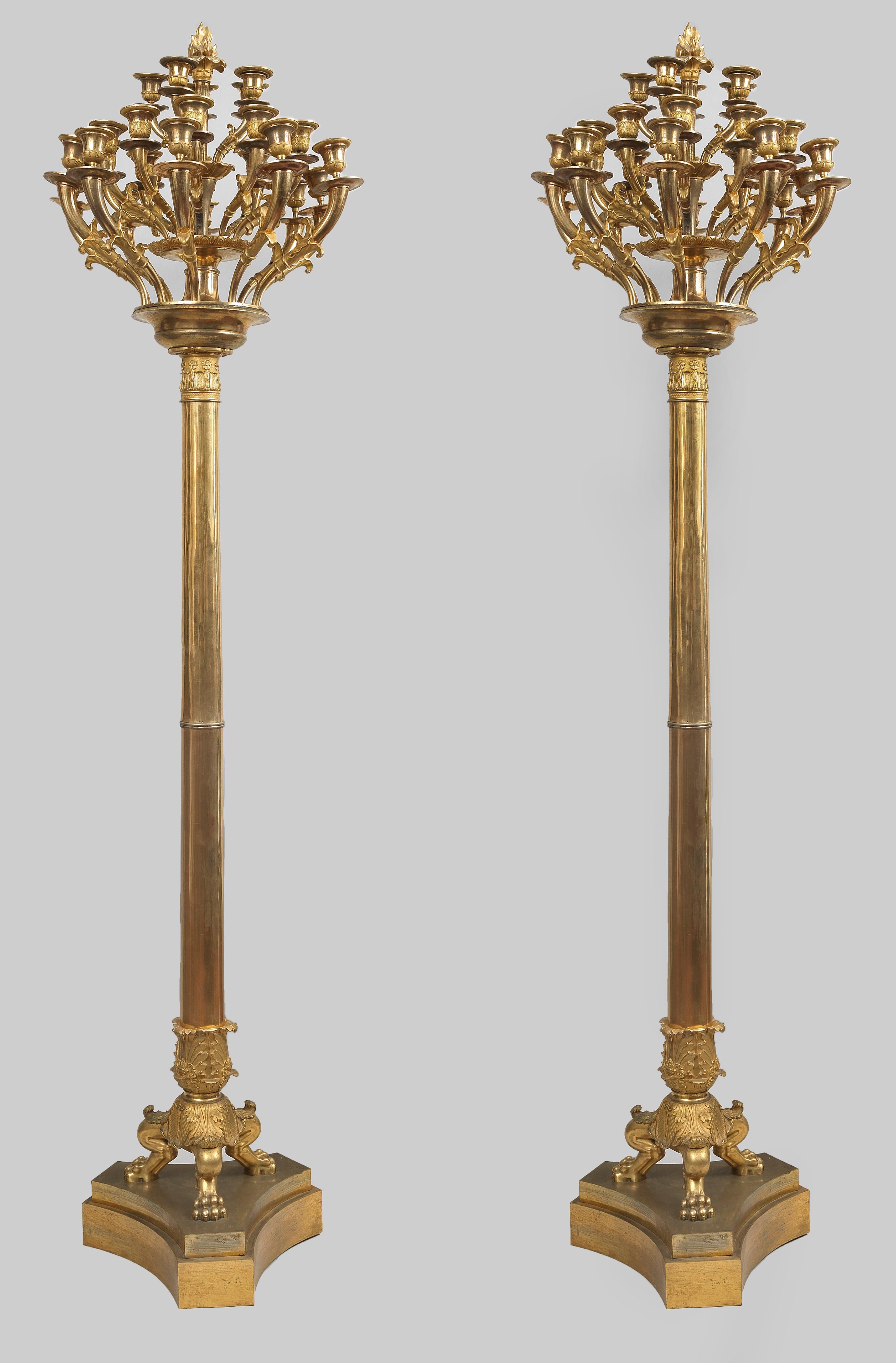 Beeindruckendes Paar italienischer Empire Flambeaux aus fein ziseliertem Ormolu, auf dreifachem Sockel, jeweils mit 25 verschnörkelten Kerzenarmen aus vergoldeter Bronze. Luigi Manfredini, dem berühmten, zu Beginn des 19. Jahrhunderts in Mailand