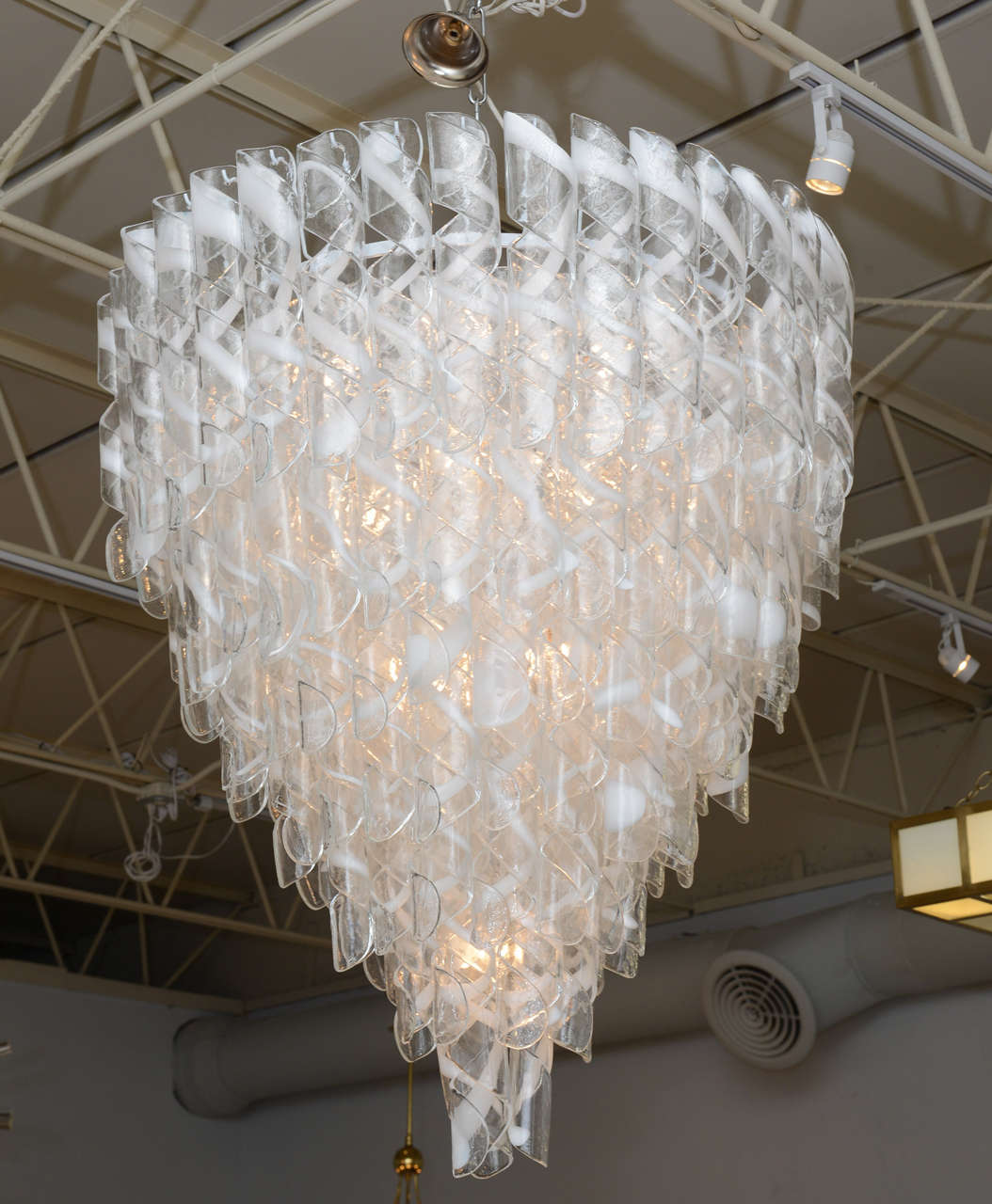 The hand blown clear and white glassine cascading circles. One chandelier available.