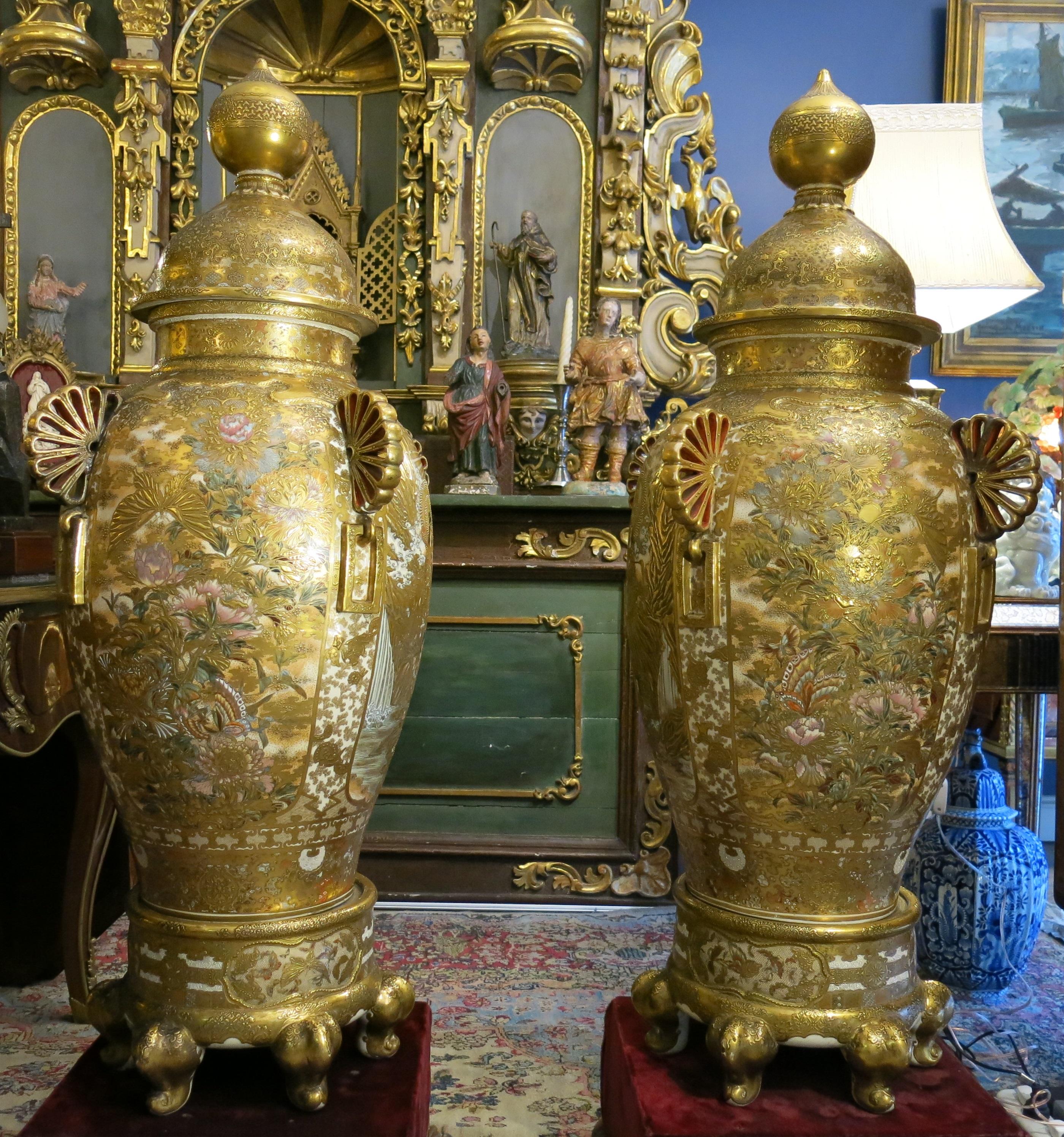 A monumental and impressive pair of Japanese satsuma vases and covers signed Dai Nihon Kinkozan kore (wo) Tsukuru and Kyoto HakubyaKuken Gako, Meiji period (19th century).
Decorated in various coloured enamels and gilt with four panels, three of