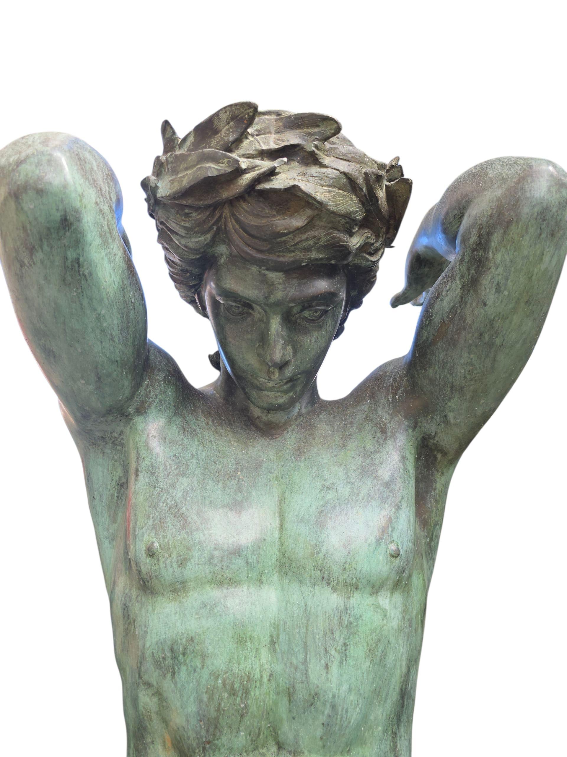 Magnificent and monumental pair of patinated bronze candelabra featuring two majestic male figures in the style of Atlas. Each figure is crowned with laurel leaves and supports an elaborate candelabrum above his shoulders, combining mythological