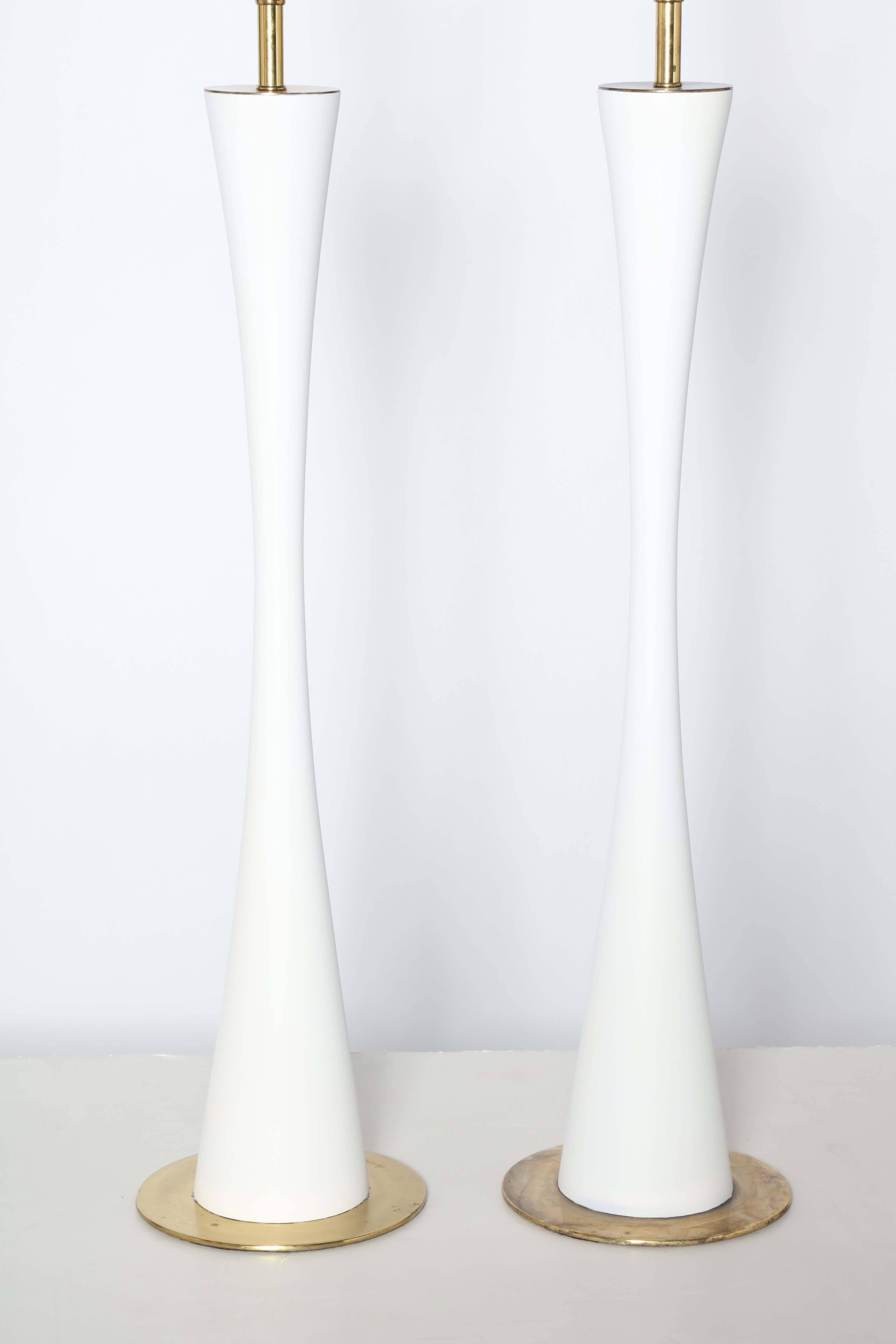 Statuesque pair of Stewart Ross James for Hansen Lighting Co. White Enameled Table Lamps. Featuring a slender, elongated hourglass form in White enameled Metal with slightly patinated Brass plated neck, cap and round 8D base. 34H to top of socket.