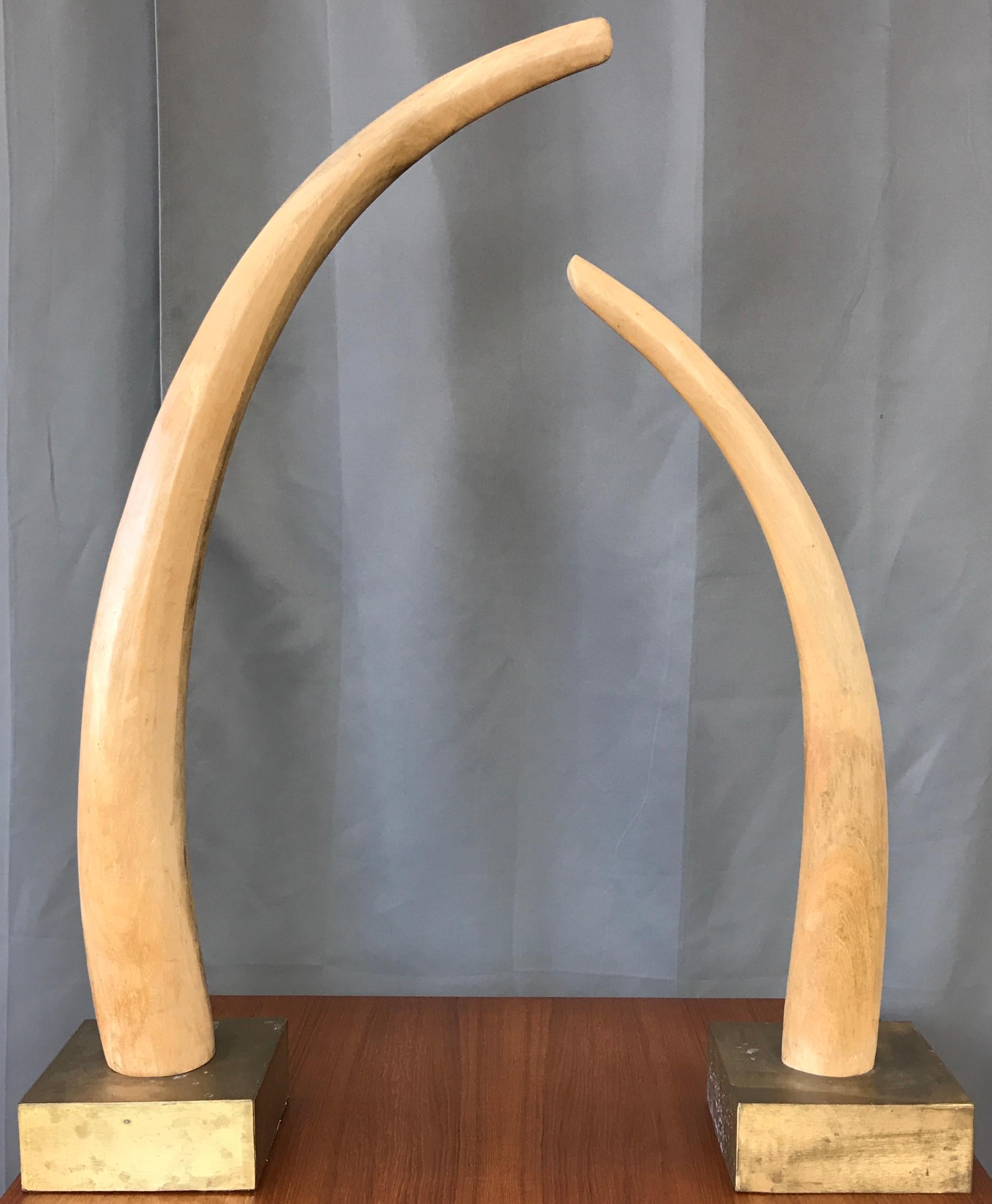 A Monumental pair of tall carved wood elephant tusks sculptures from Africa, both on square brass bases.
Bases themselves are 7.75 x 7.75 x 3.25, short one is about 31.50 inches tall and the taller one about 39.25 inches tall.