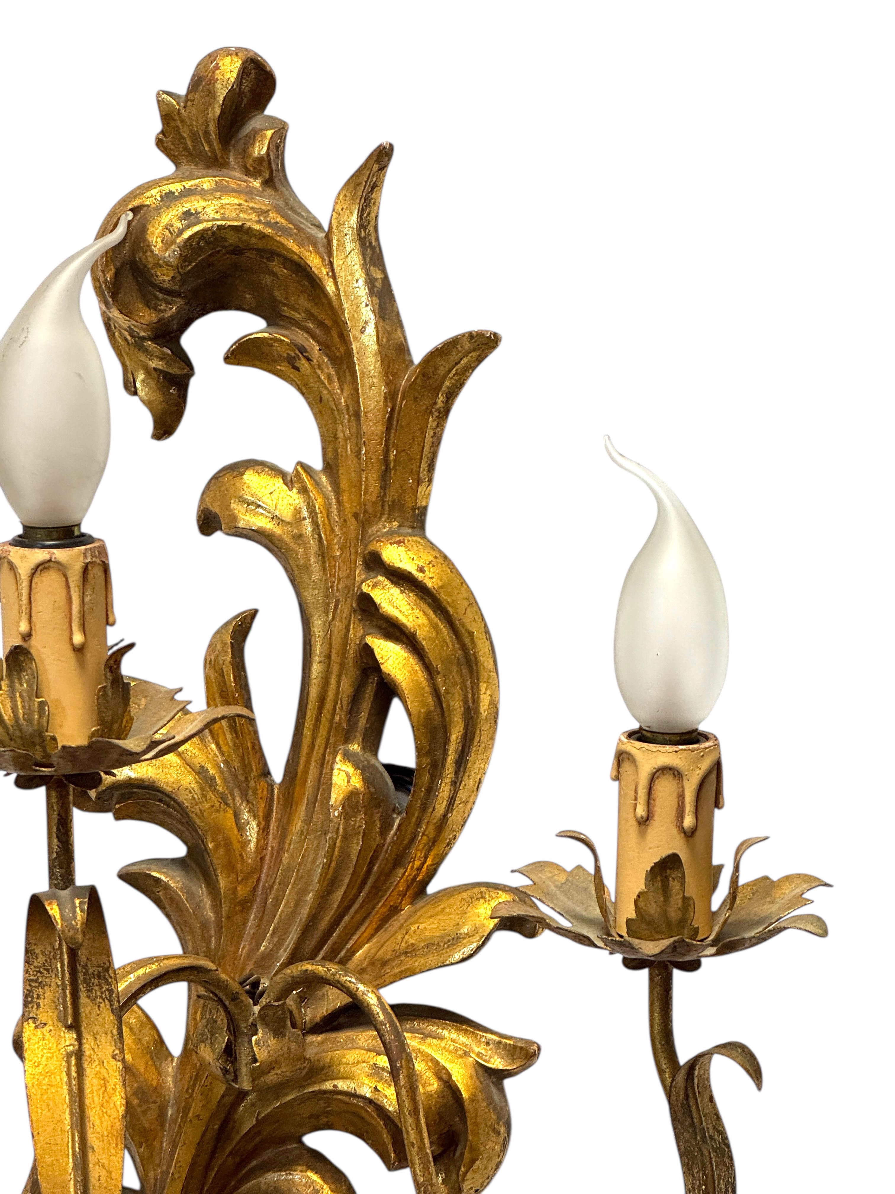 Añade un toque de refinada opulencia a tu interior con este encantador par de apliques italianos. Talladas a mano en madera y acabadas en un elegante dorado, estas luminarias aportan un carácter cálido y artesanal que complementa a la perfección los