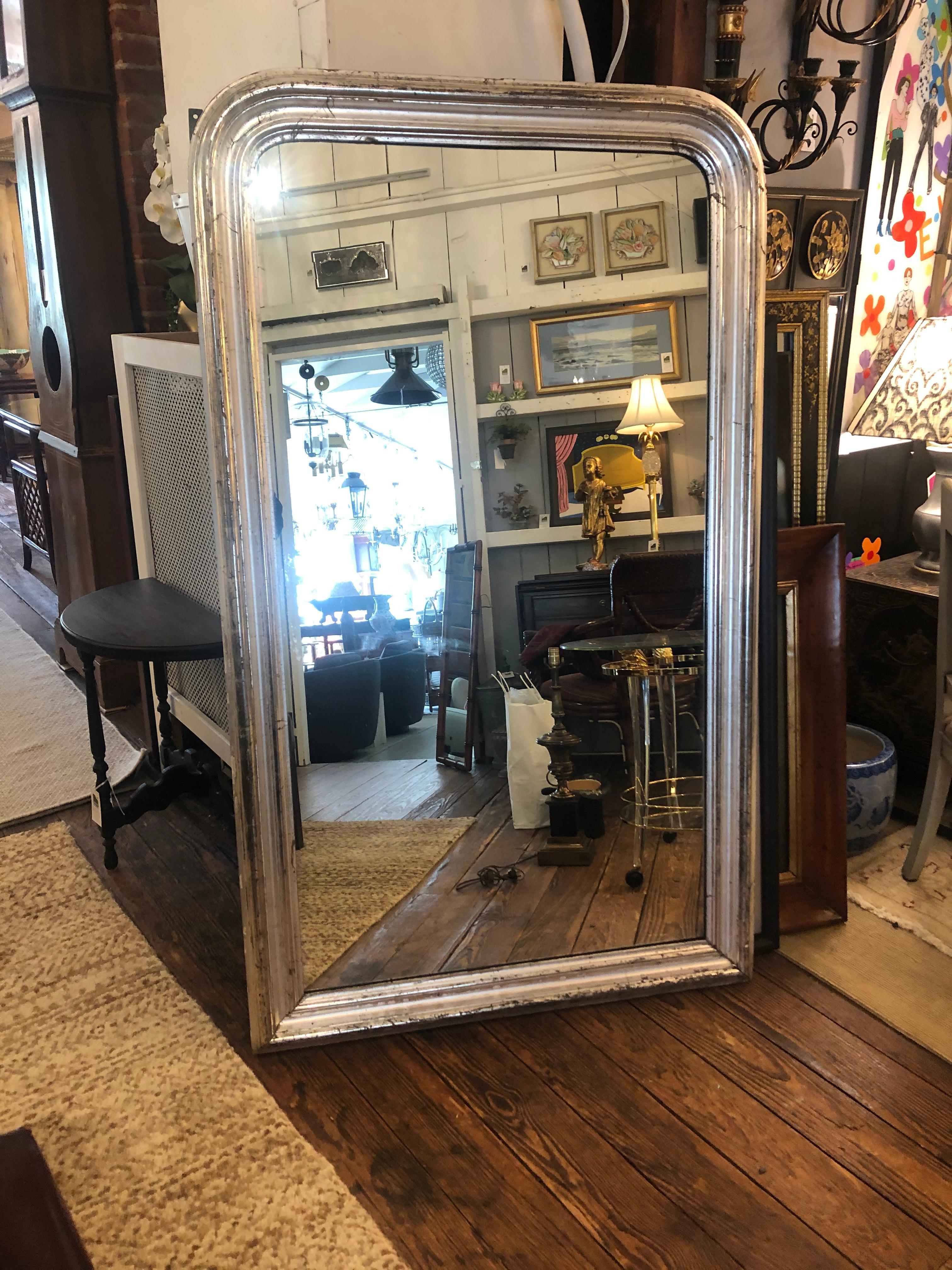 A show stopper palatial in scale antique silver leaf Louis Philippe mirror having gorgeous classic curved top and aged patina.