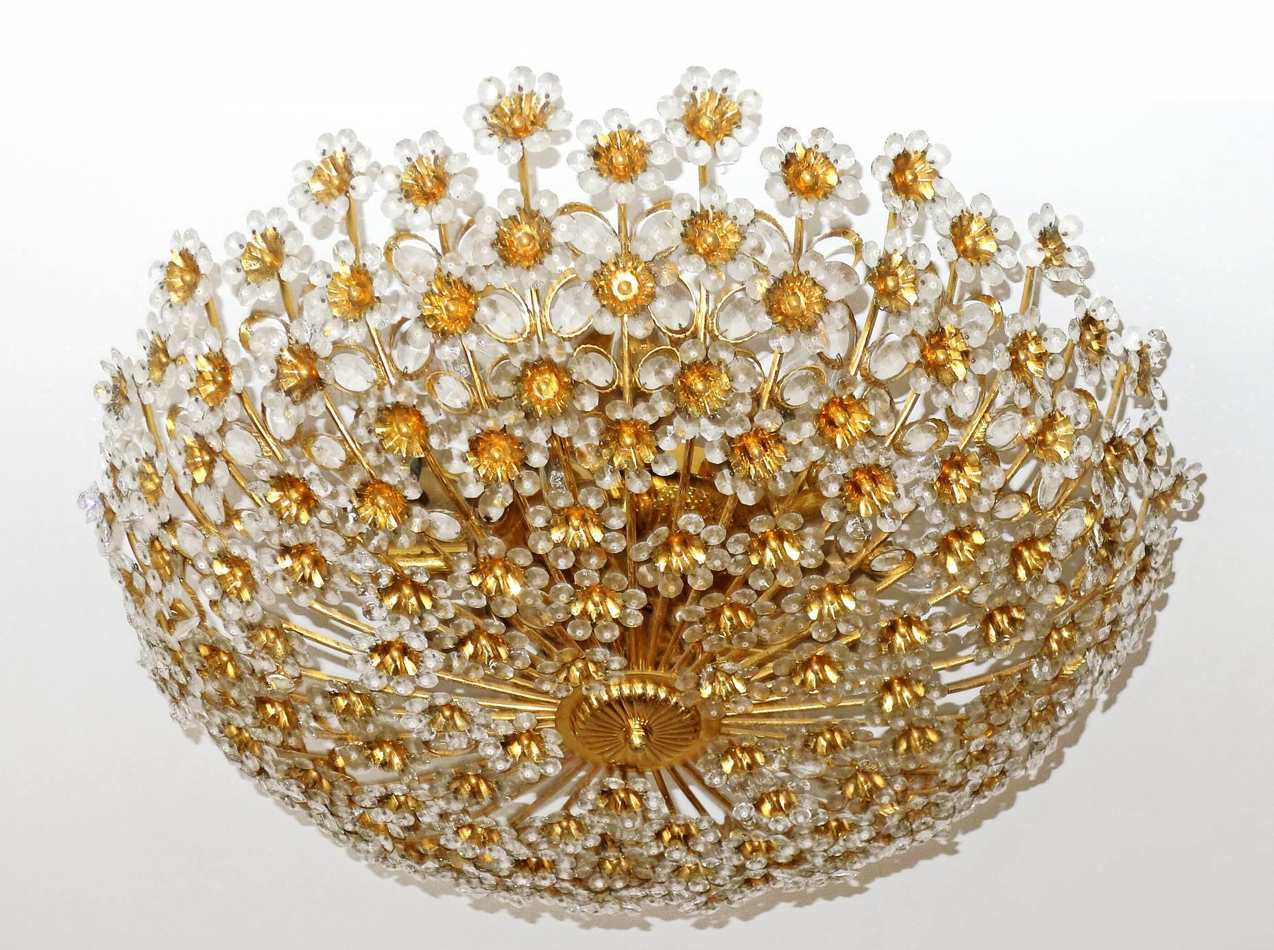 Stunning gigantic high quality luxury gold-plated brass chandelier. Very shiny with fabulous mirror effect and sparkling countless beautiful handcut faceted crystals in the shape of flowers. Original vintage condition, no missing crystals. Age