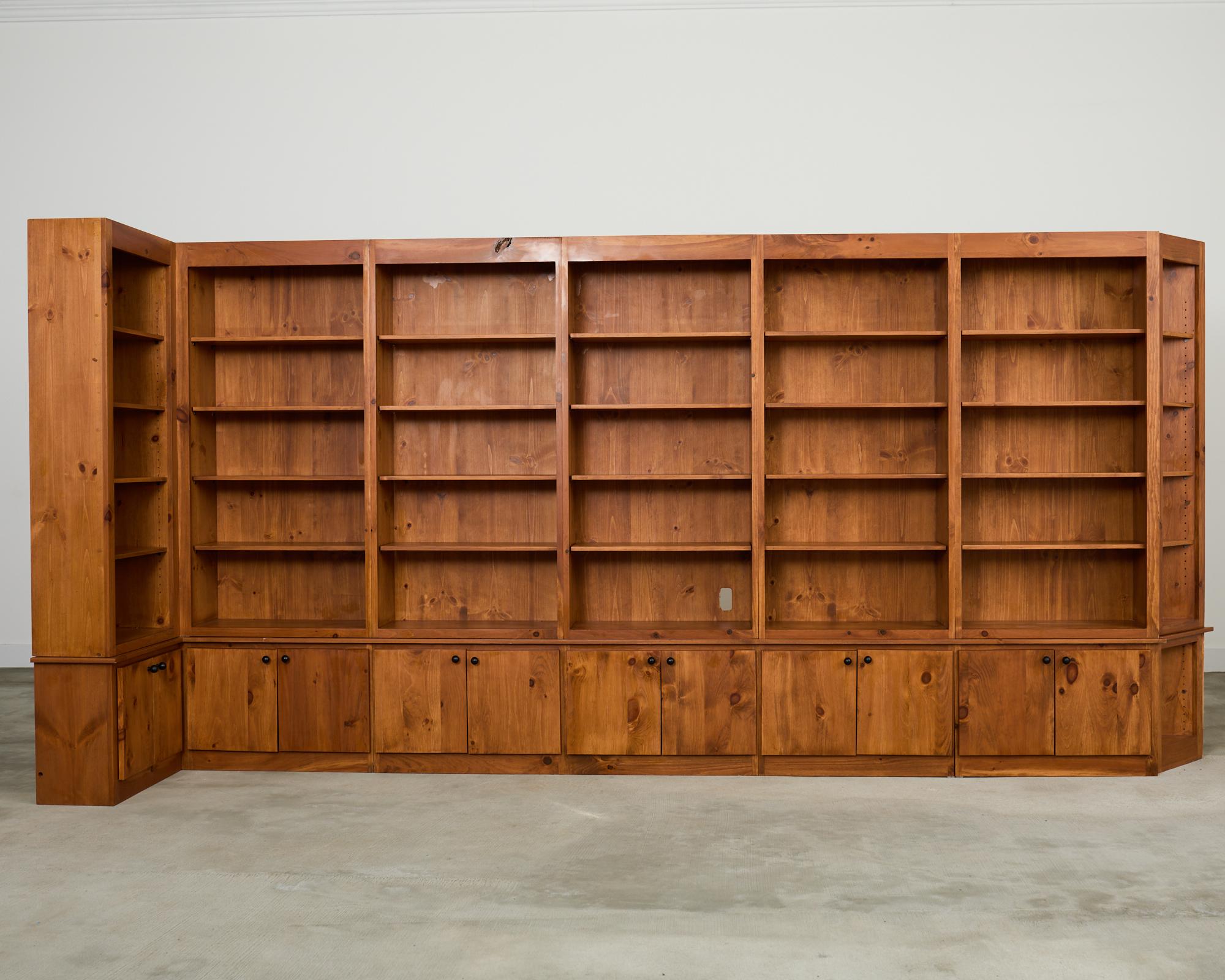 Libreria-armadio su misura composta da diverse sezioni realizzate su scala monumentale in legno di pino. L'intera unità, come mostrato, misura più di 15 piedi di larghezza e dispone di 6 scaffali, ciascuno con una coppia di cassetti sul fondo e un
