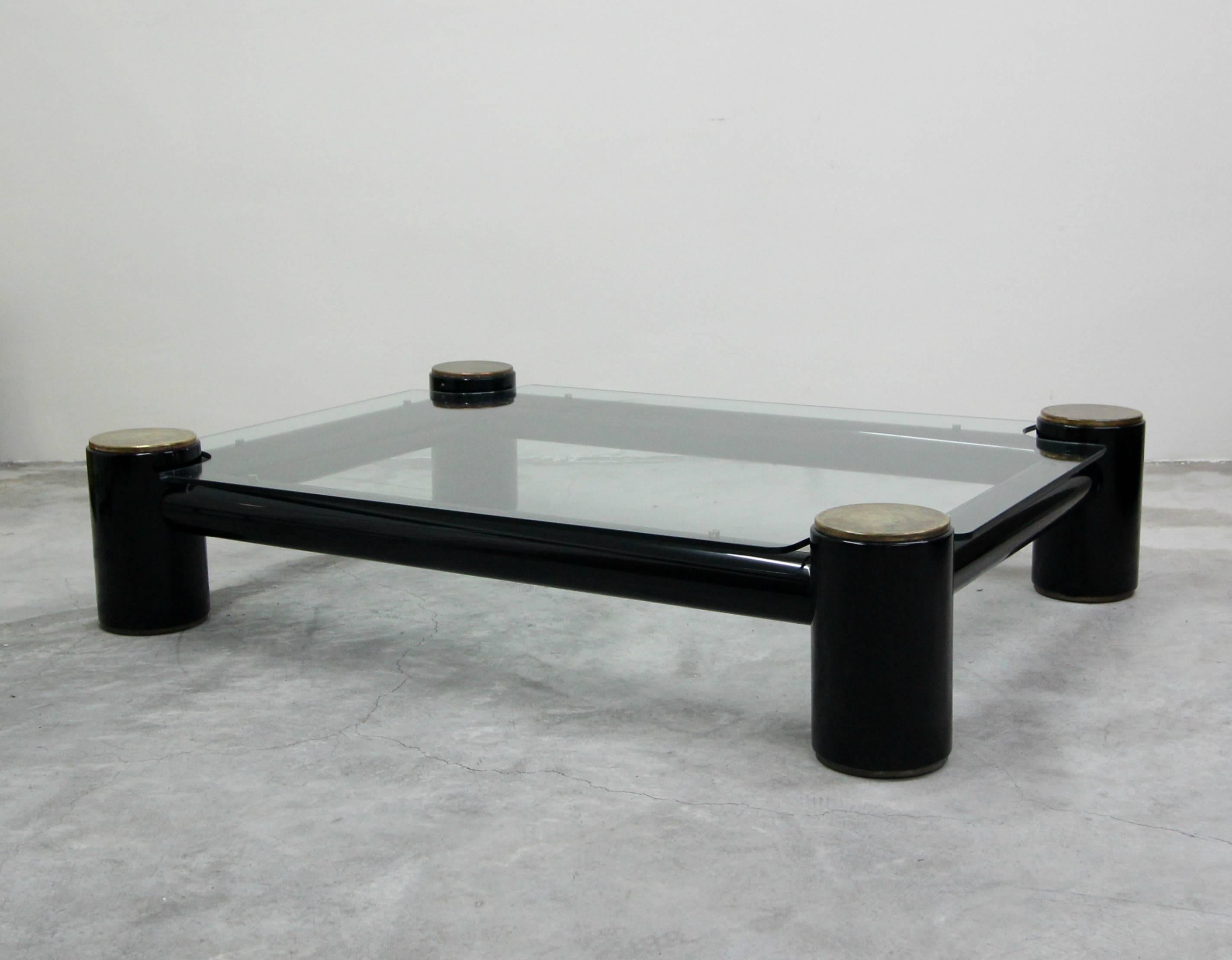 Monumental Postmodern acrylic tube brass and glass coffee table, most likely custom. Constructed of large black acrylic pipe like tubing with eye catching brass caps and feet and a beautiful puzzled piece of glass. If you are in need of a huge table