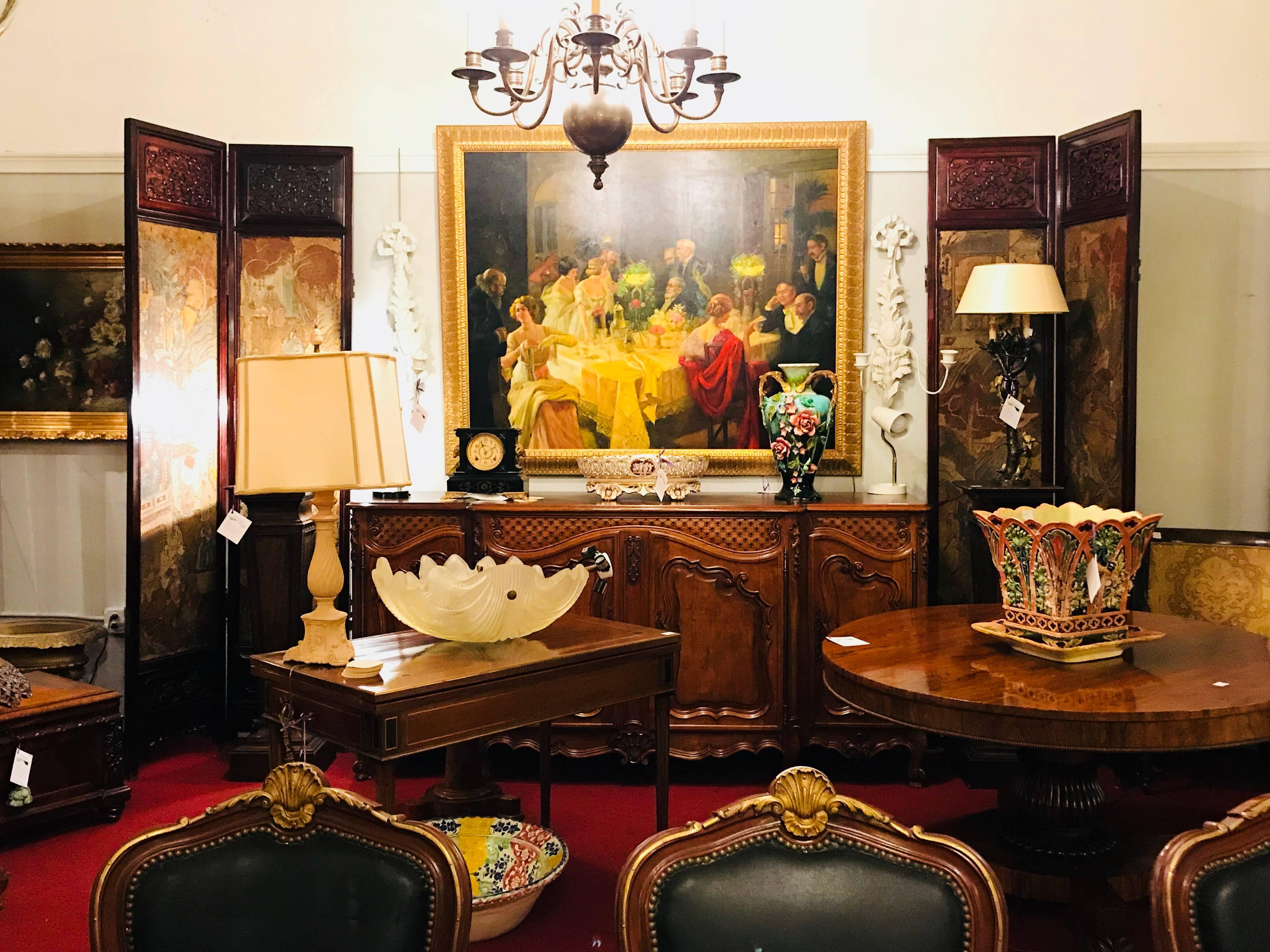 A Monumental print painting oil on canvas of a party scene in a great gilt frame. Signed by E. Coleridge this party genre scene is mounted in a custom designed leaf carved gilt gold painting frame.