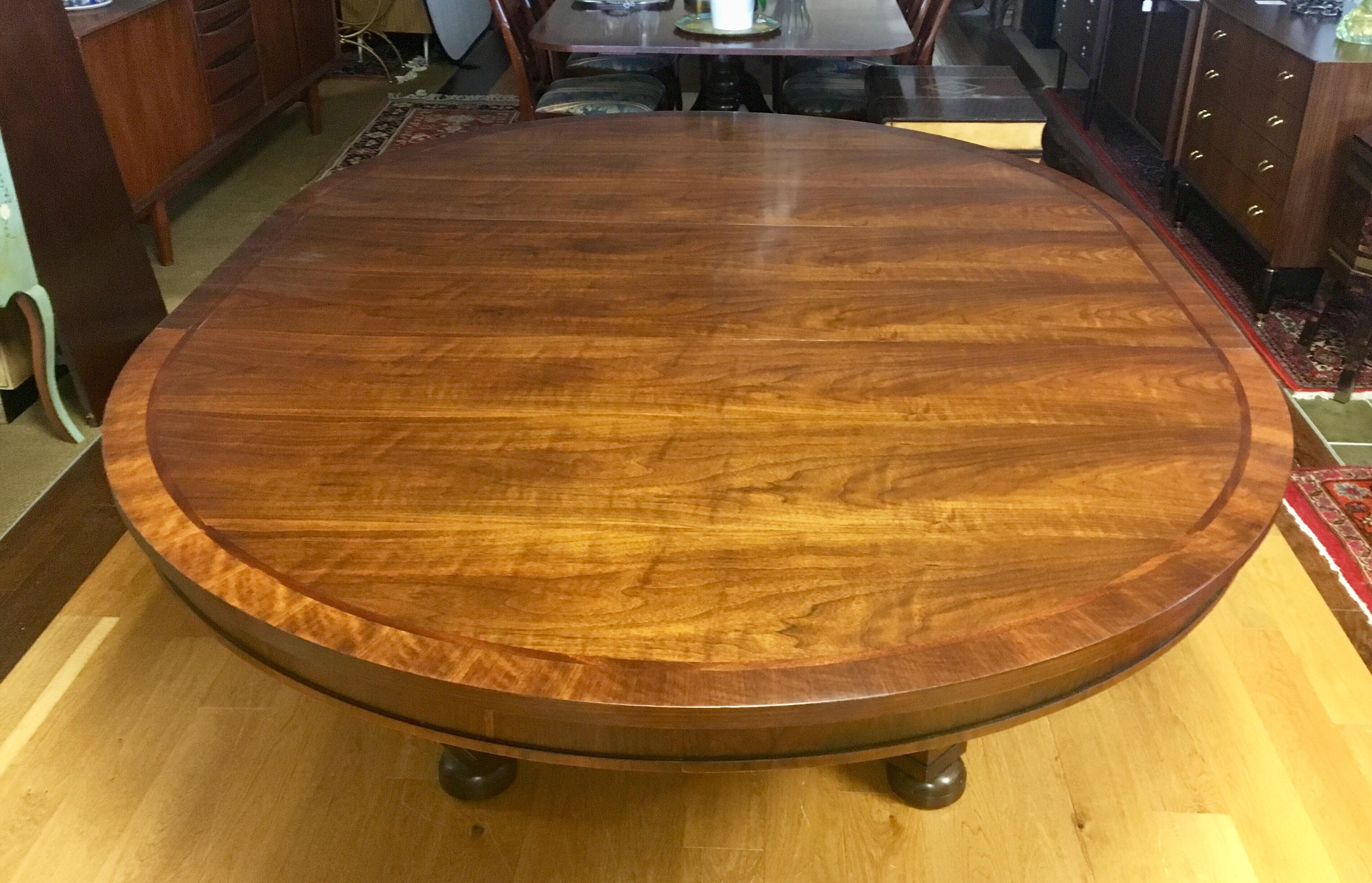 Ralph Lauren in partnership with Henredon Furniture large circular pedestal walnut and mahogany dining table that is shaped more oval when large 20 inch leaf is in. Without leaf it is 64 inches round and substantial. It sits on a gorgeous pedestal.