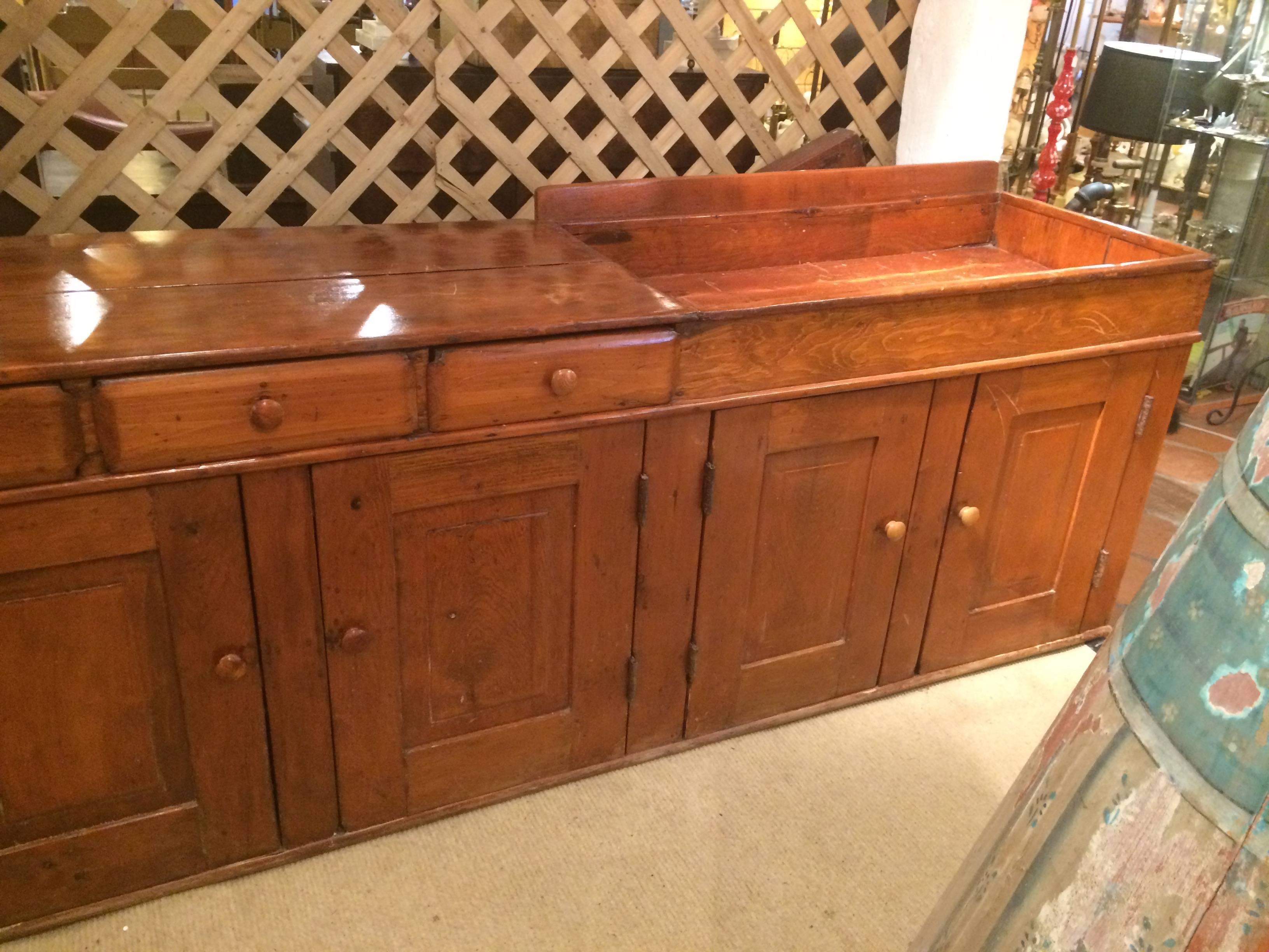 A spectacularly long and rare vintage dry sink cabinet having a rectangular sink measuring 41.5 L x 4.5 H, with tons of storage including 3 drawers and two sets of panelled doors that open to shelves inside. Top is pine and bottom may be ash.