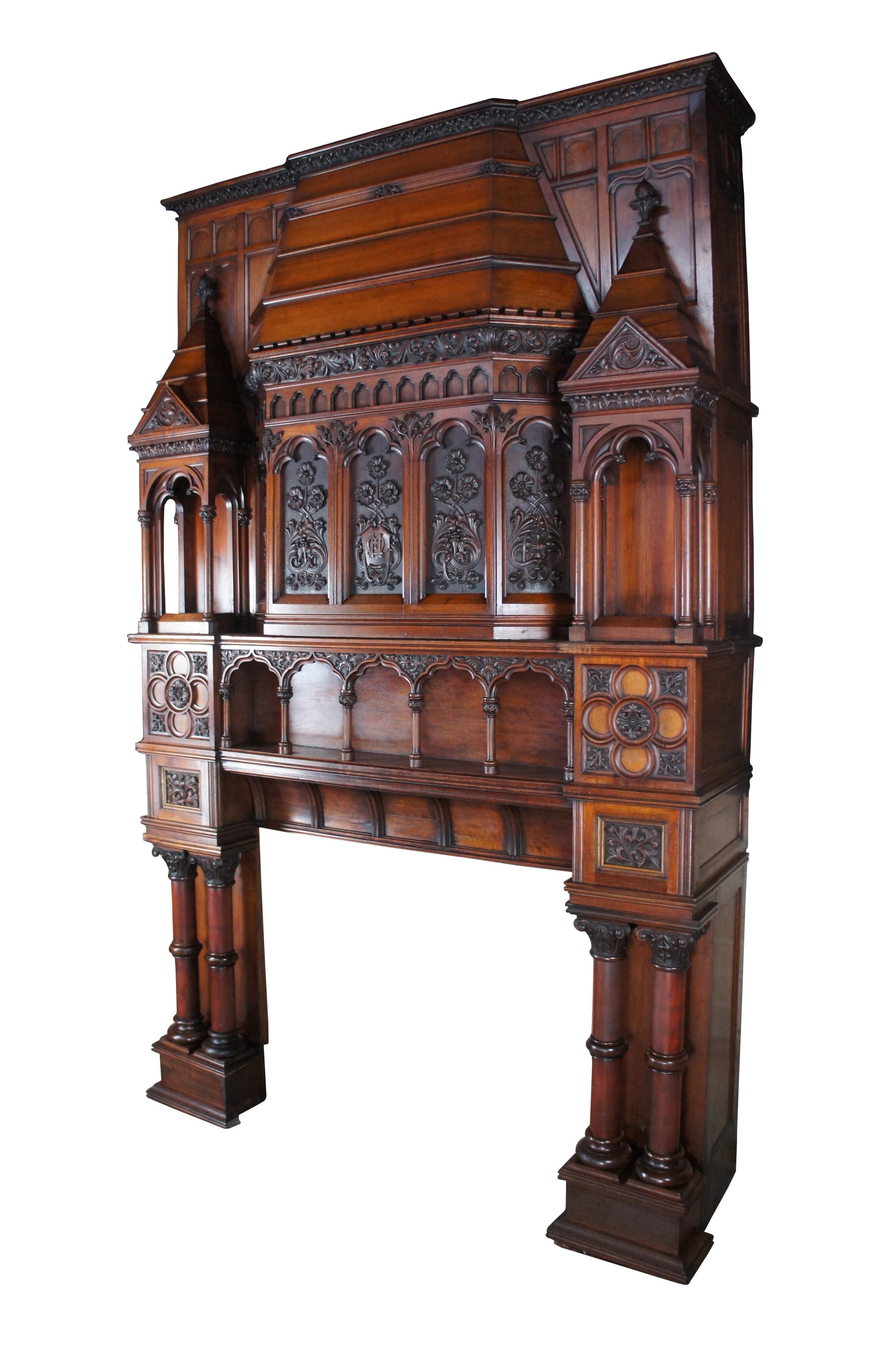 Very large and exceedingly rare English Renaissance Revival fireplace mantel, circa 1860s.  Made of hand carved walnut featuring a gothic cathedral design.  The fireplace portion is set between ornate Corinthian columns with carved capitals and a