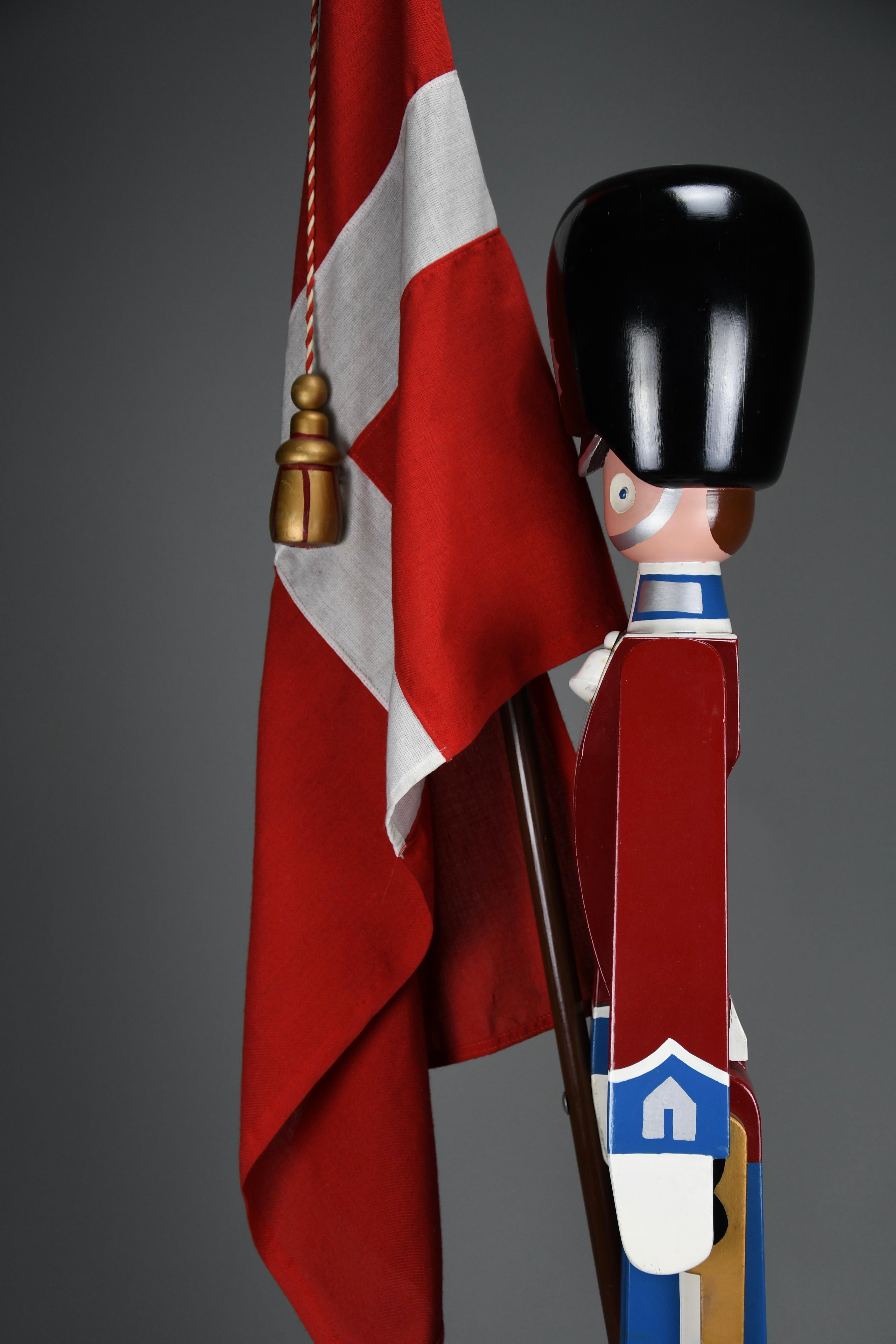 Monumental Royal Danish Guardsman with Flag by Kay Bojesen — 168 cm (66.1 in), 1950s

A very rare XL model of the Royal Danish King’s Guardsman designed by Kay Bojesen in the 1950s. Hand-crafted in wood and retaining its vivid original paint, the