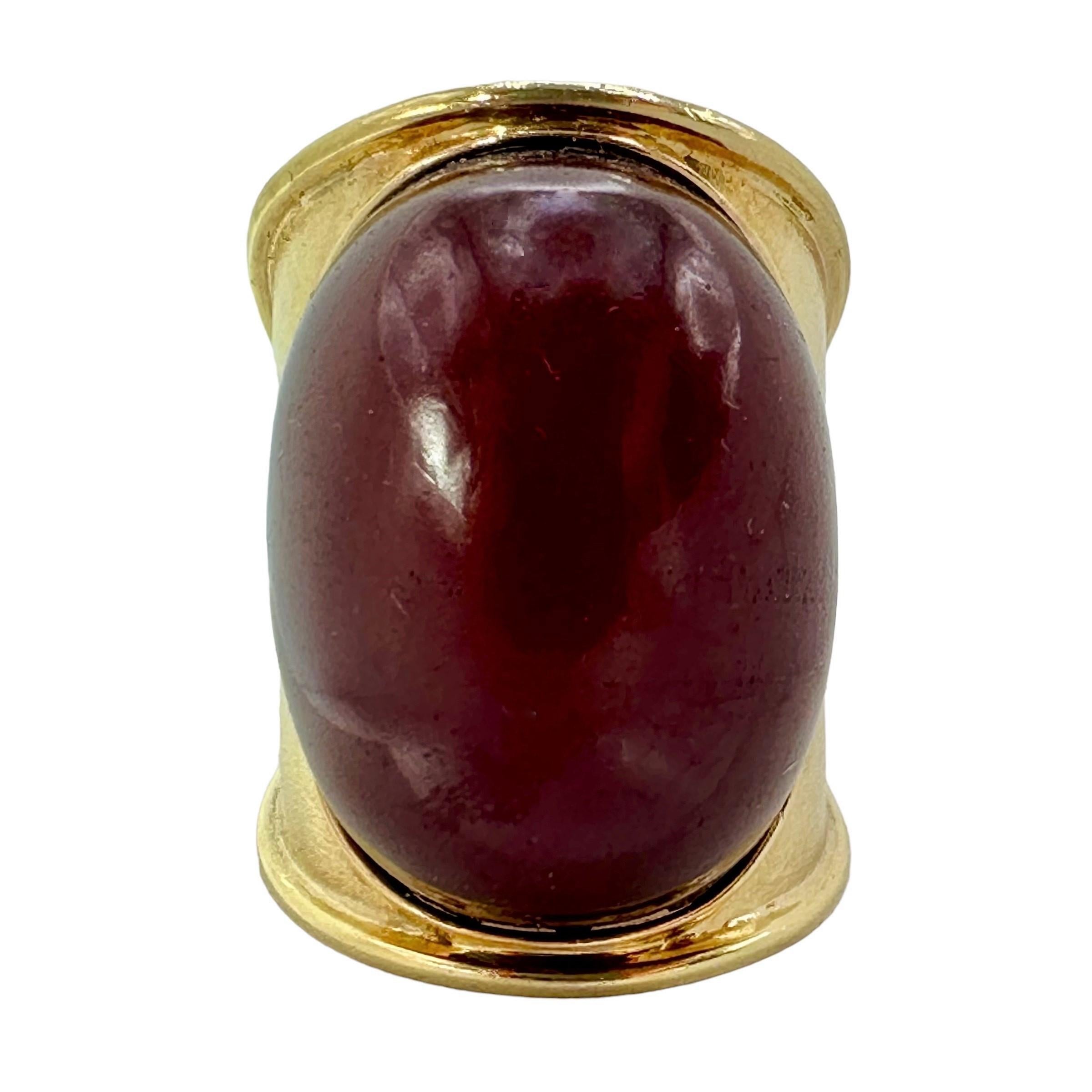 This unusual vintage ring is crafted from 18K yellow gold with a richly textured surface. It is set with one massive amber bead, which measures a full 1 1/8 inch in length with a girth of over 3/4 inch. The bead is a rich, reddish-bronze  color. The