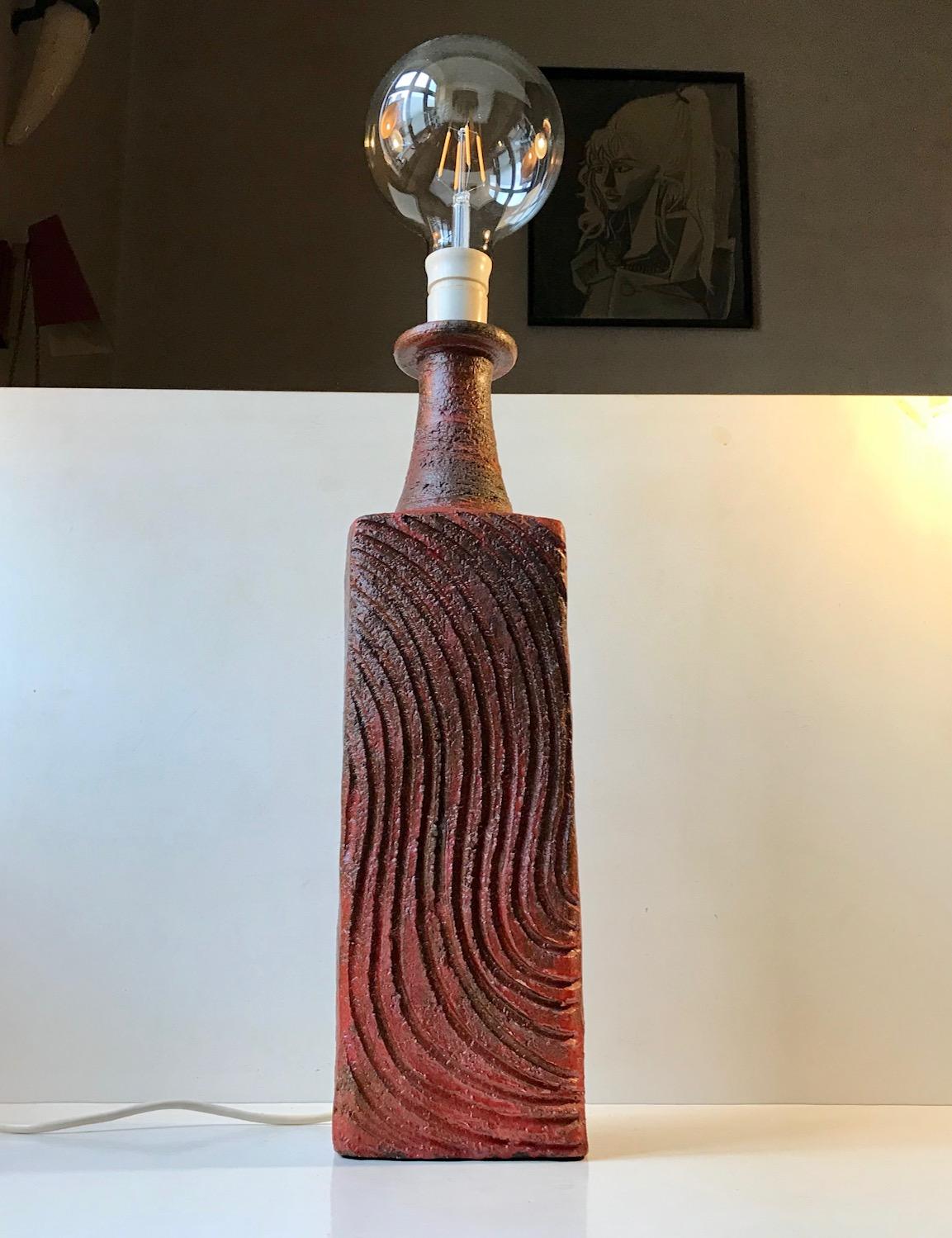 Unusually glazed monumental table lamp in stoneware. Decorated with vertical hand-incised waves. Presumably from a Studio in Ribe Denmark where its was made as a piece unique during the 1970s. Its signed indistinguishable to the side. Measurements: