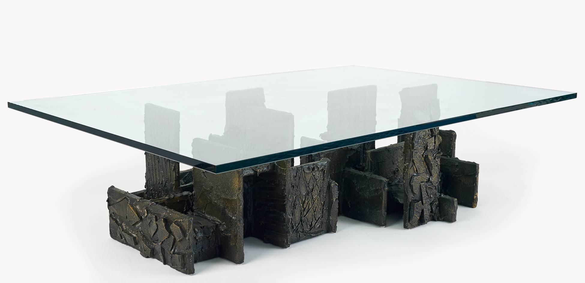 Paul Evans (1931–1987)

A sculptural brutalist coffee table by Studio Craft Movement leader Paul Evans, in bronze. The architectural base —comprised of textural interlocking facets vigorously hand sculpted with contrasting motifs— rises like a