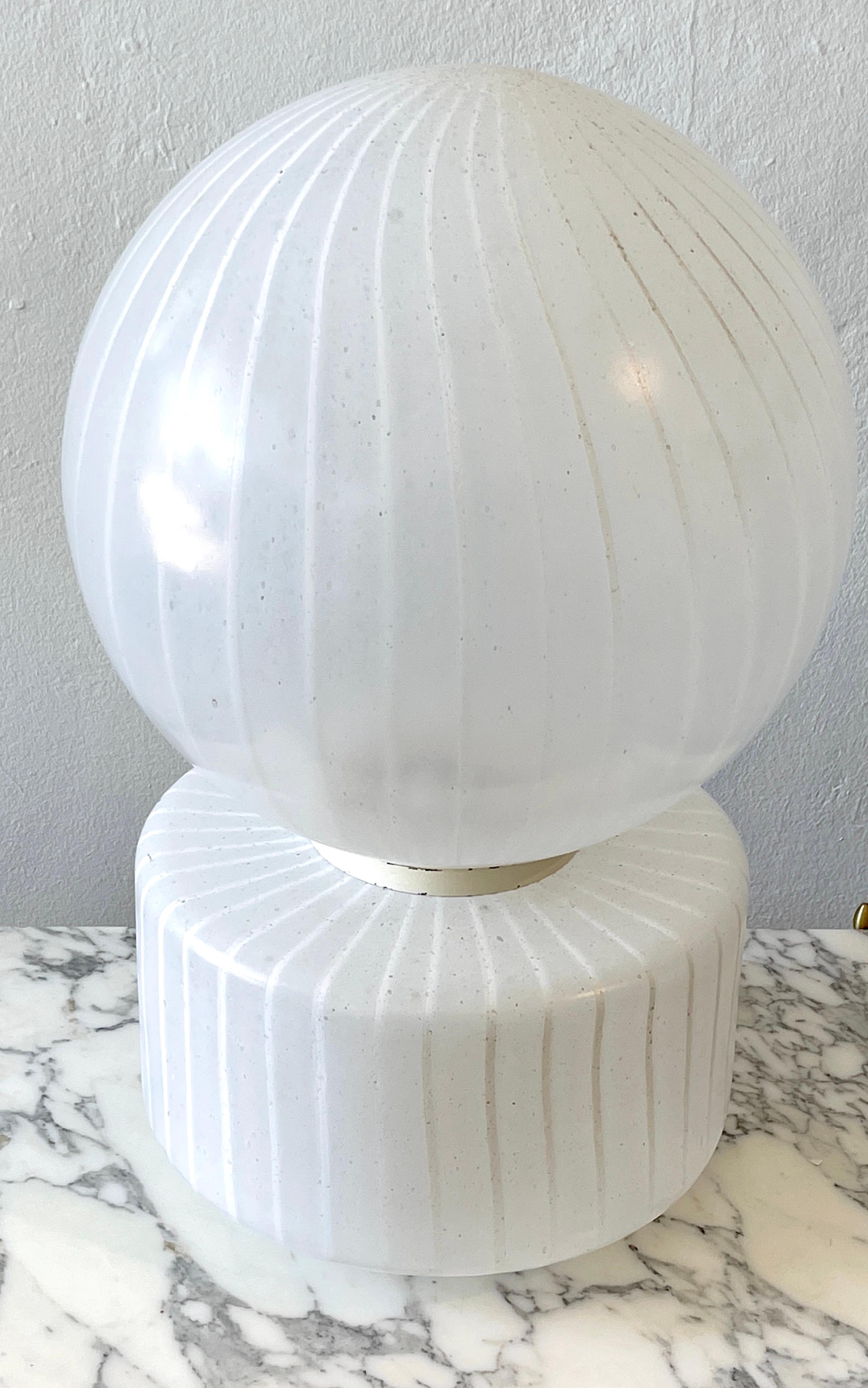 Monumental sculptural 2-piece white striped murano- vistosi glass table lamp.
Italy, Circa 1950s

A large and early masterwork, in two parts with the hand blown 15-Inch diameter round shade with white opaque back-ground with continuous internal