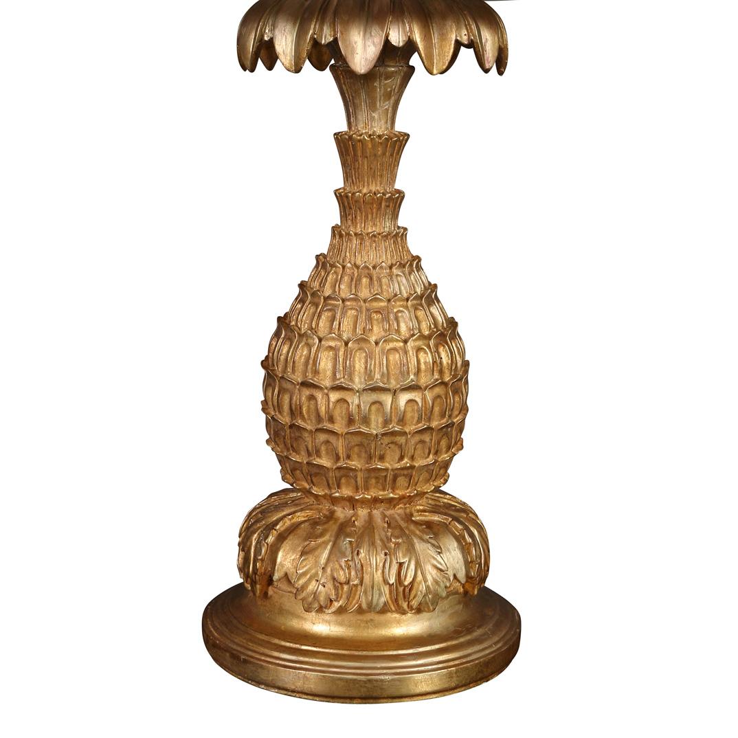 A monumental Serge Roche style gilt pineapple lamp crafted of gesso with foliate details at top and acanthus leaf motif at gold round base.  A grand, Hollywood Regency style lamp makes a statement in any room.  Lampshade is sold separately.