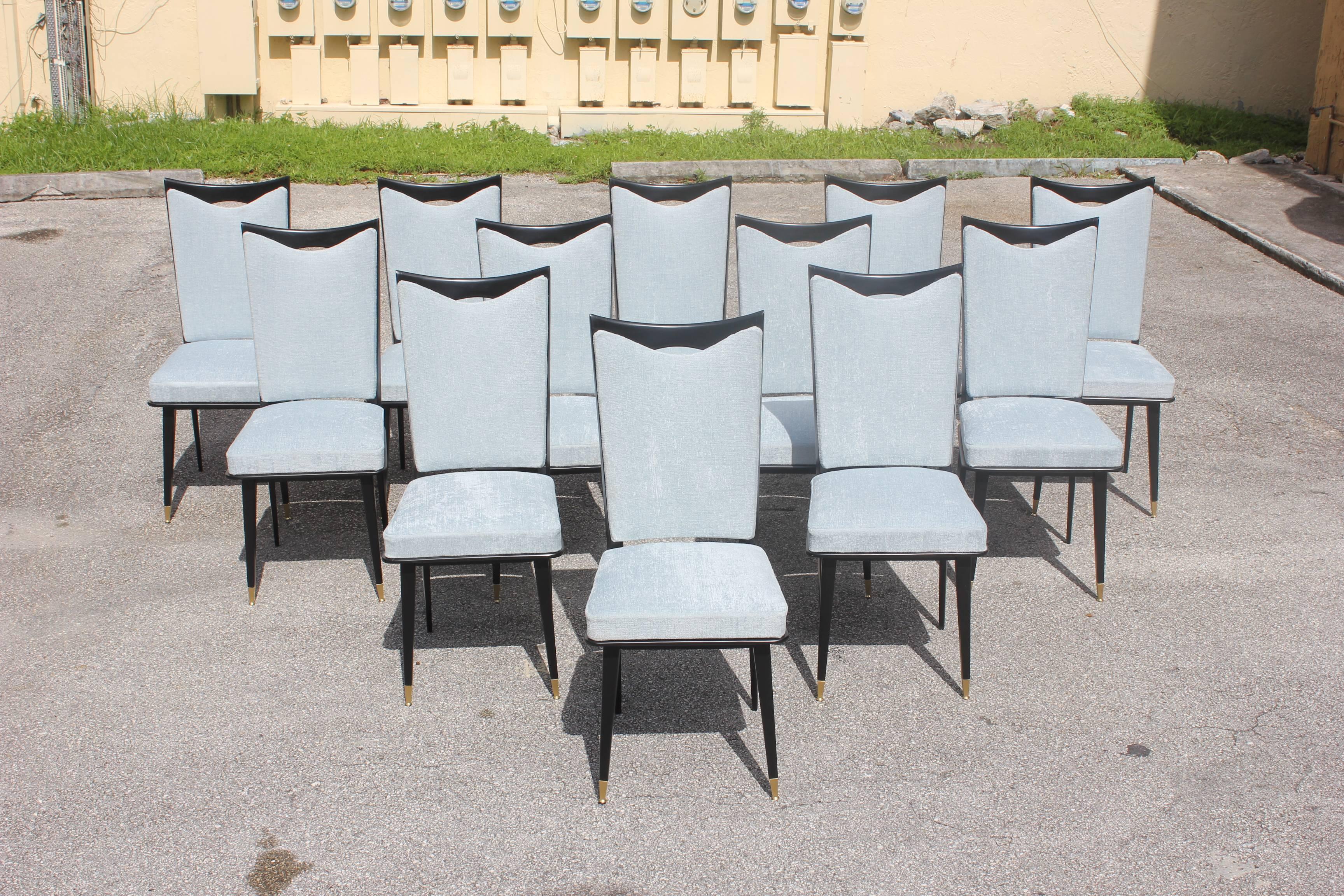 Monumental set of 12 French Art Deco dining chairs, with frames made of solid mahogany that have been ebonized and finished with a French polish, the two front feet are capped with brass caps, very elegant dining chairs, the chair frames are in