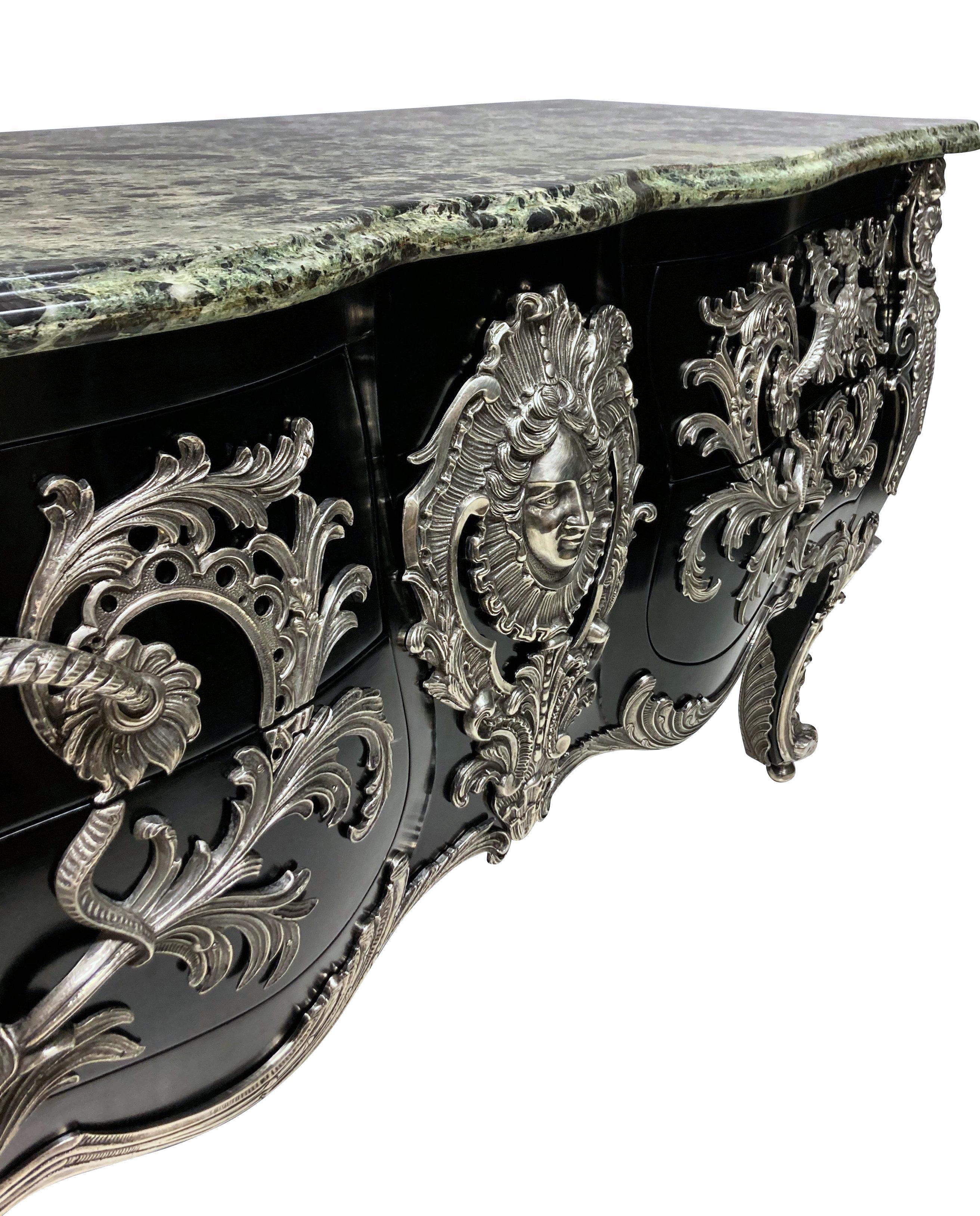 A monumental French commode a vantaux after the Model by Antoine-Robert Gaudreaux. The serpentine verde alpi marble top above a rocaille-framed Apollo mask and two pairs of serpentine drawers mounted with dragon and acanthus handles. The sides with