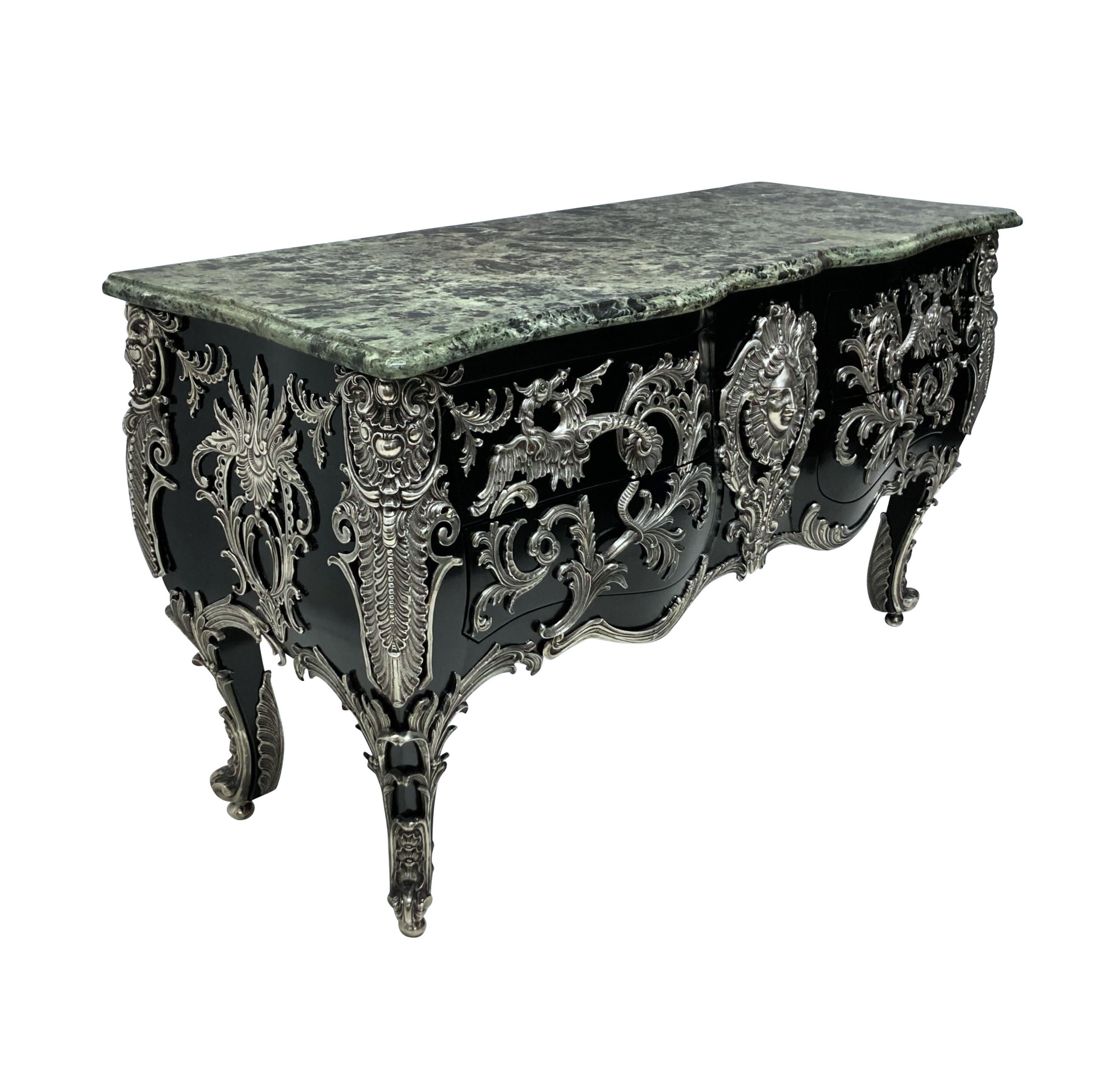 A monumental French commode a vantaux after the Model by Antoine-Robert Gaudreaux. The serpentine verde alpi marble top above a rocaille-framed Apollo mask and two pairs of serpentine drawers mounted with dragon and acanthus handles. The sides with
