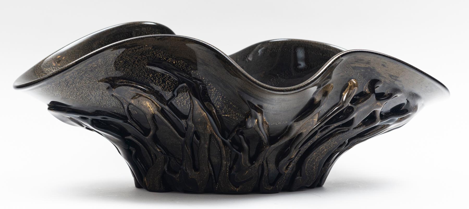 Stunning oversized glass blown centerpiece signed by the artist and created by blowing gold over the black glass to create a matte bronze color.

Origin: Murano, Italy

Dating: Contemporary

Condition: Excellent

Dimensions: 18″ deep, 25″ long,