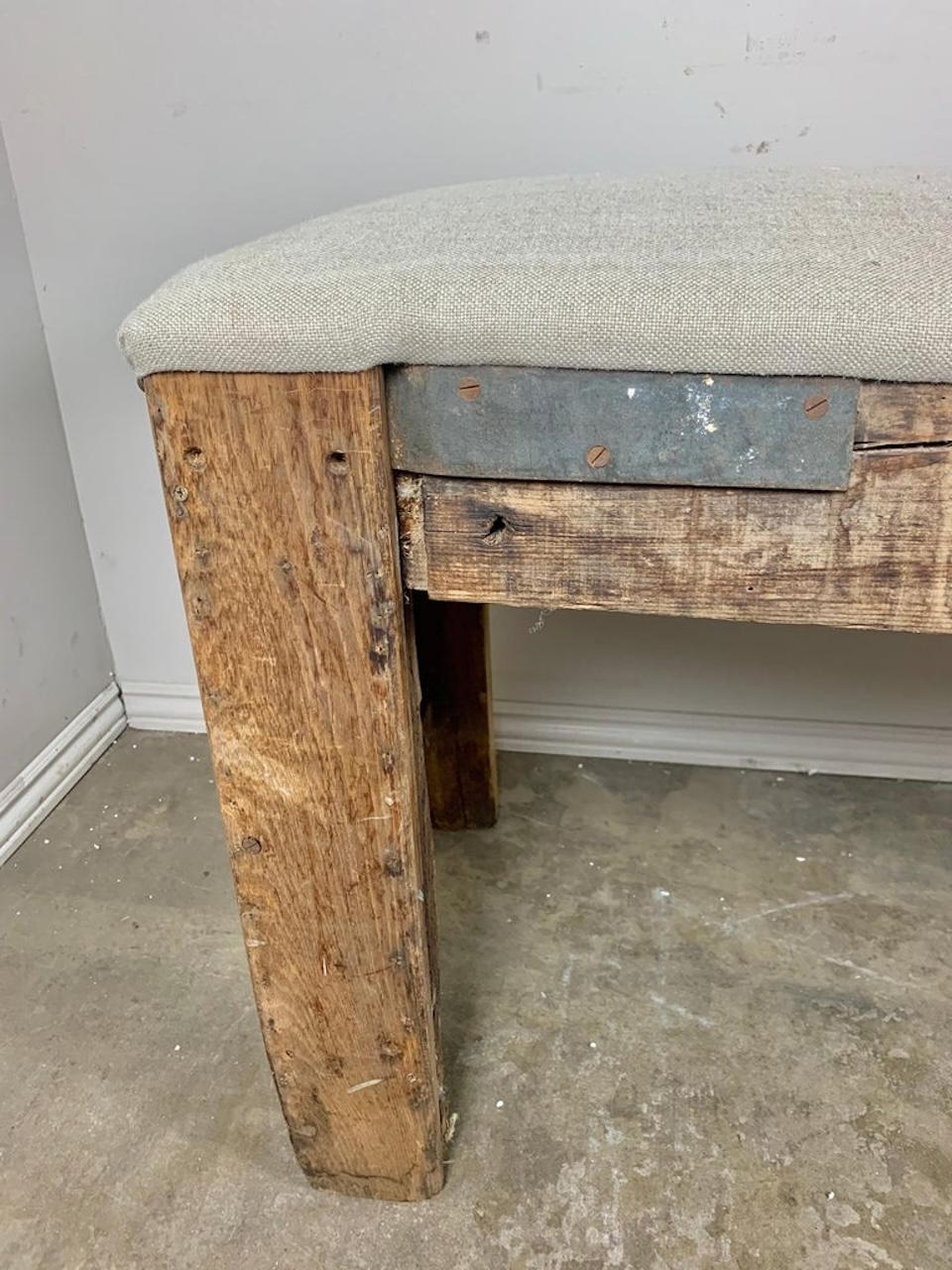 Banc en bois sculpté espagnol du début du 19e siècle représentant de magnifiques boucliers détaillés, des fleurs de lys et bien d'autres choses encore. Ce banc de taille monumentale a été récemment tapissé en lin belge avec des têtes de clous en