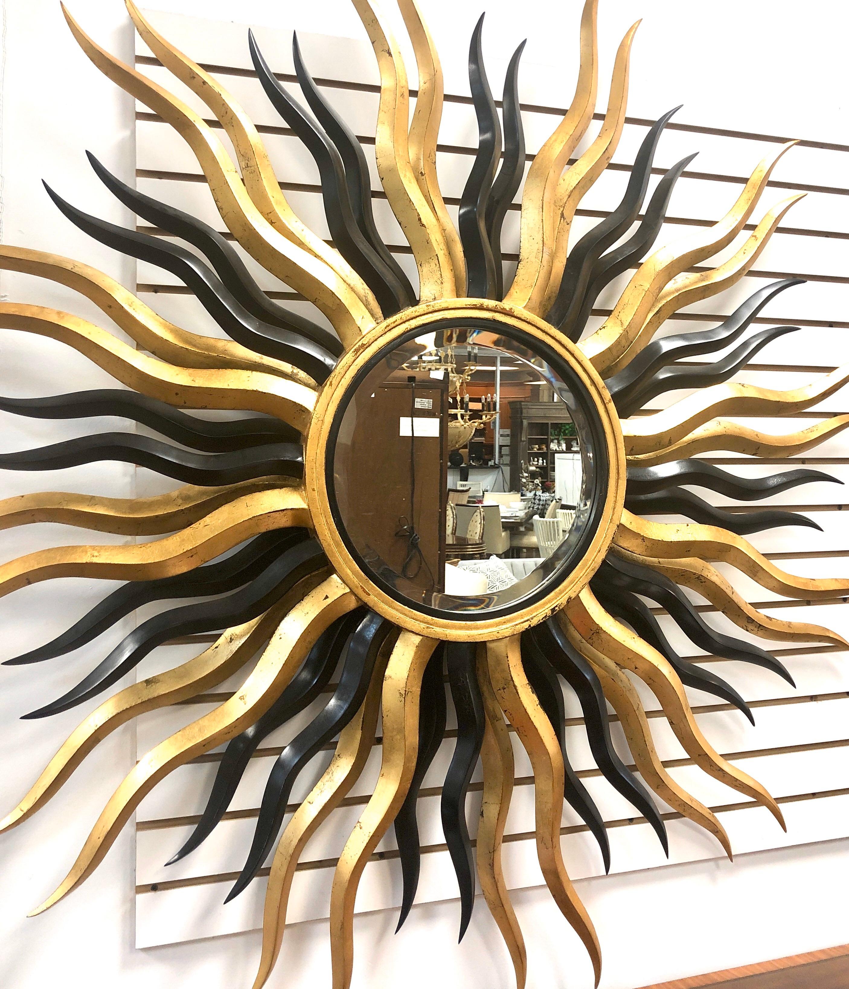 A monumental starburst wall mirror by Harrison-Gil. It is 60