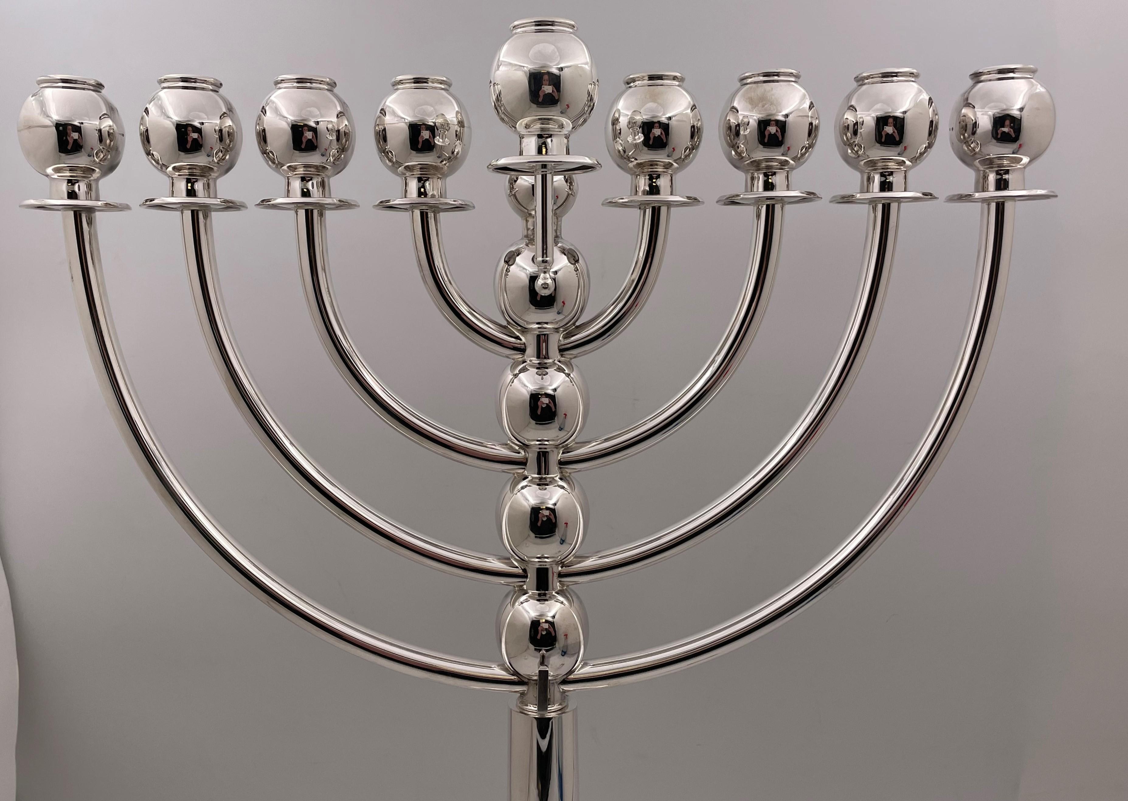 Monumental, sterling silver menorah in Mid-Century Modern style with an elegant, curvilinear design, measuring 21 1/3'' in height by 16 3/4'' from arm to arm by 6'' in depth, as well as an oil pitcher measuring 3 3/4'' in height. Total weight is