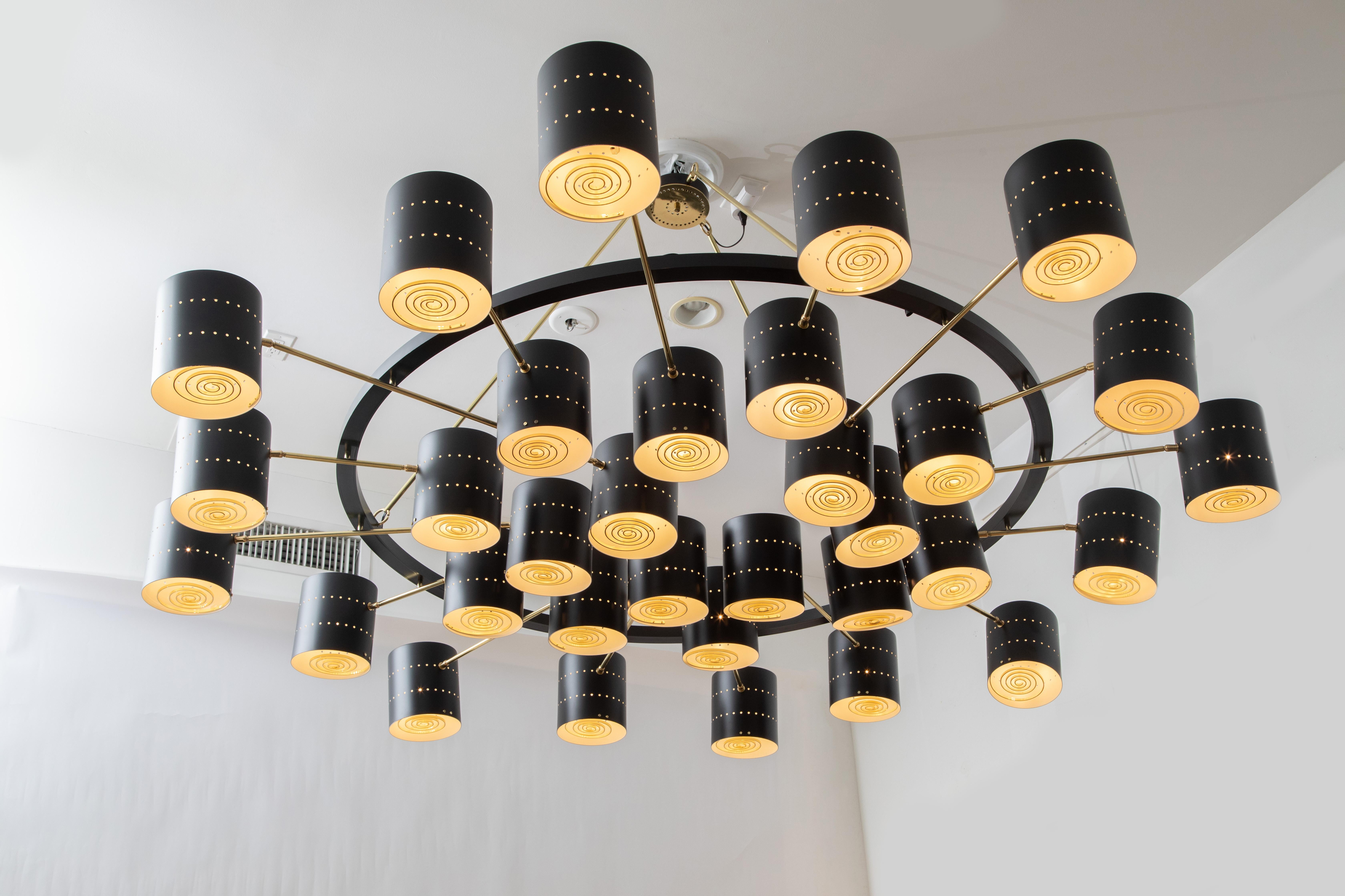 Monumentale lampadario in metallo perforato e ottone costruito in studio, in stock
Grande lampadario circolare da 86