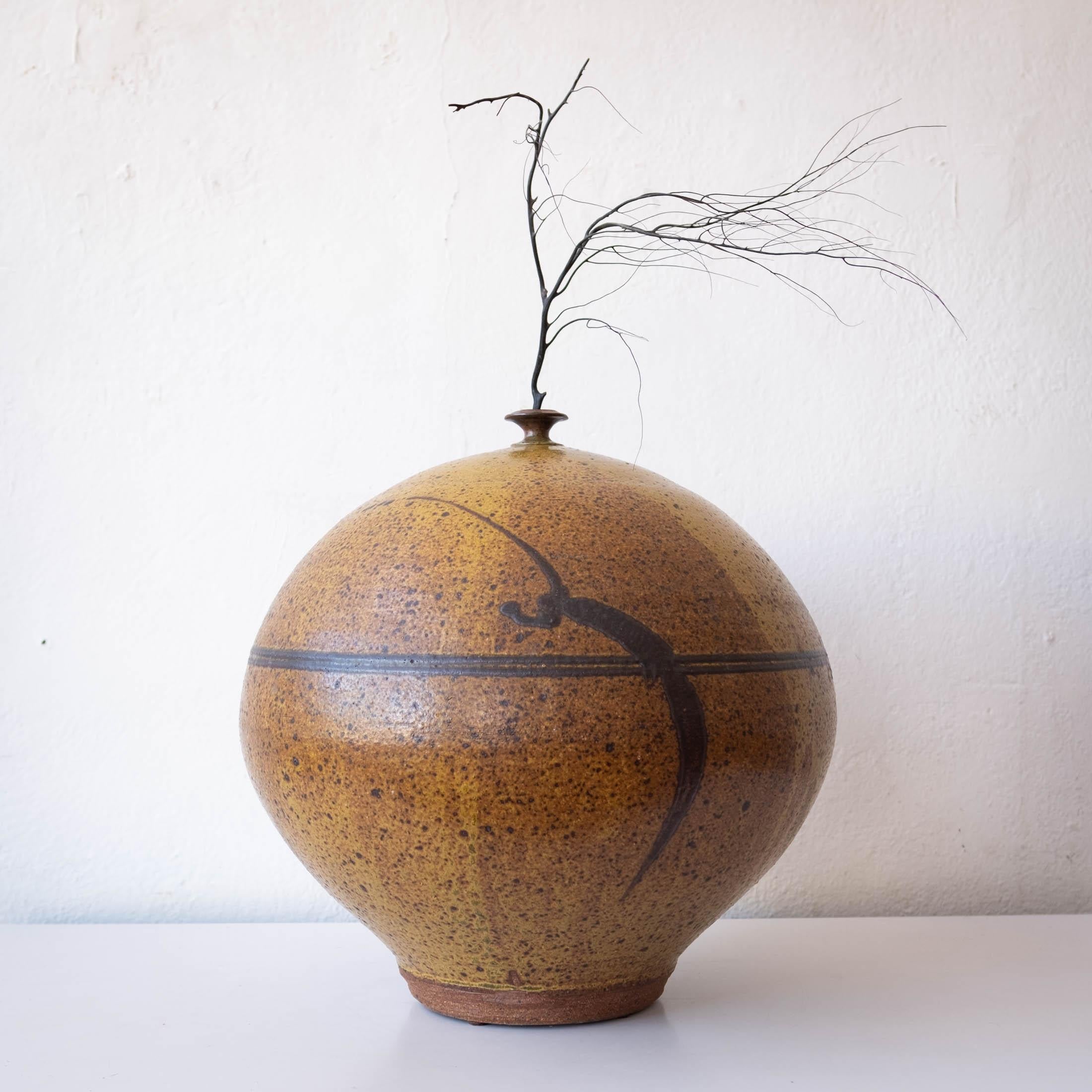 Large studio ceramic weed pot by northwest artist Jerry Glenn. Based in Portland, Oregon Glenn studied under Ray Grimm. This wheel-thrown piece has both an incredible glaze and form. Calligraphy brush decoration depicting a rope wrapped around the