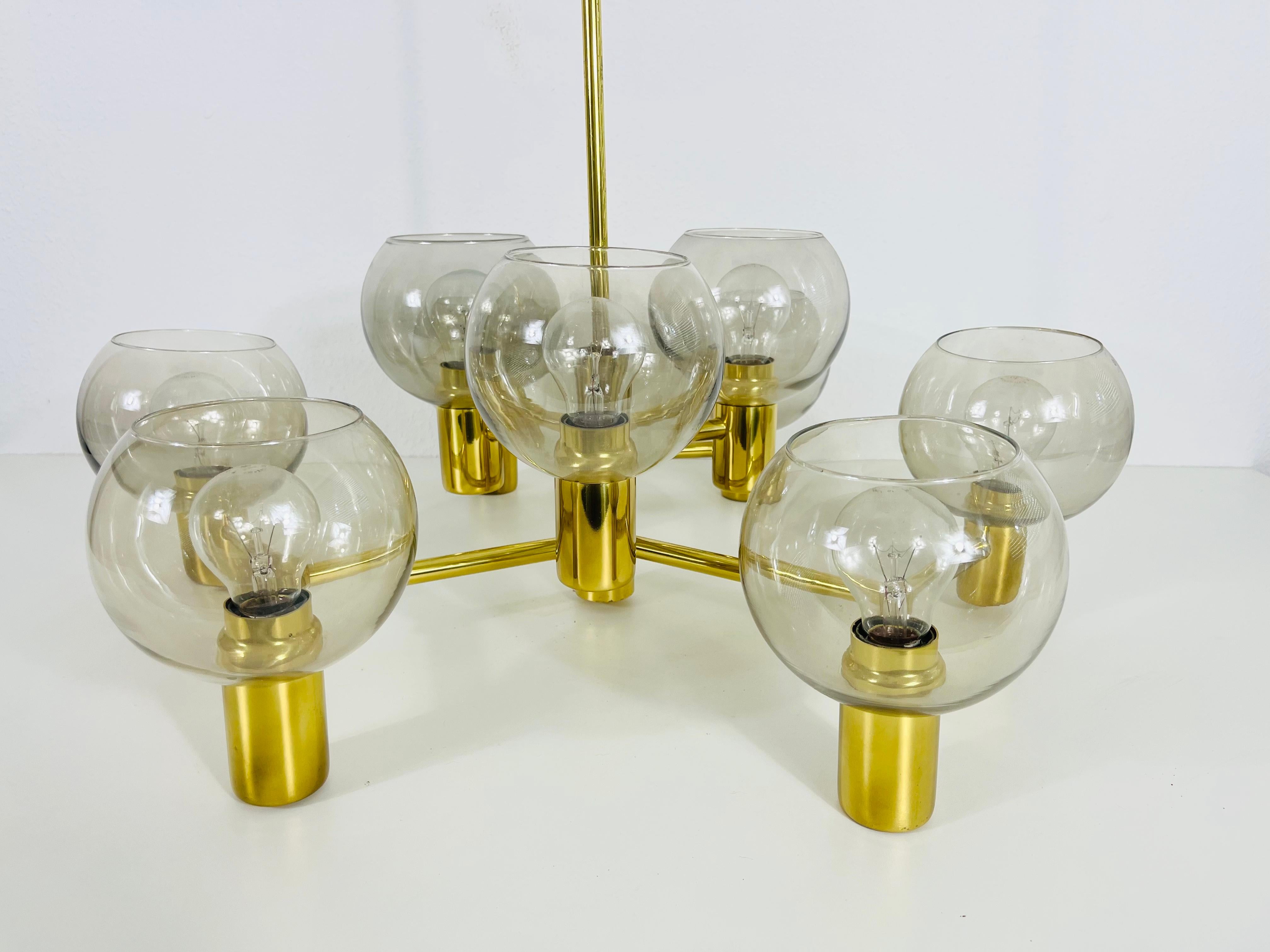 A Swedish midcentury chandelier made in the 1960s, attributed to Hans-Agne Jakobsson. It is fascinating with its monumental design and 9 glass elements. The body of the light is made of polished brass, including the arms.

Good vintage condition.