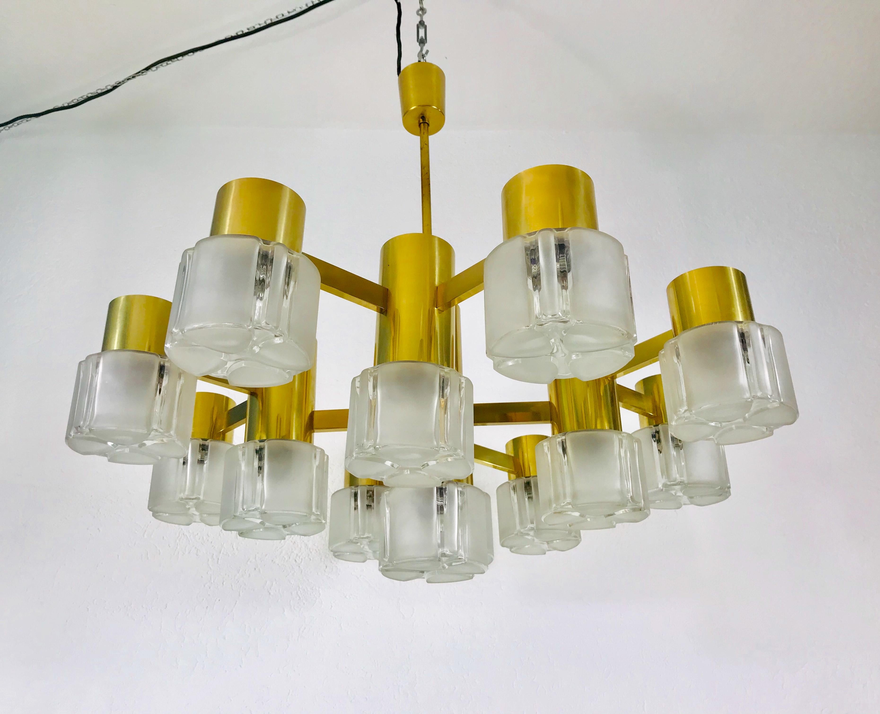A Swedish midcentury chandelier made in the 1960s, attributed to Hans-Agne Jakobsson. It is fascinating with its monumental design and 13 glass elements. The body of the light is made of polished brass, including the arms.

Excellent vintage