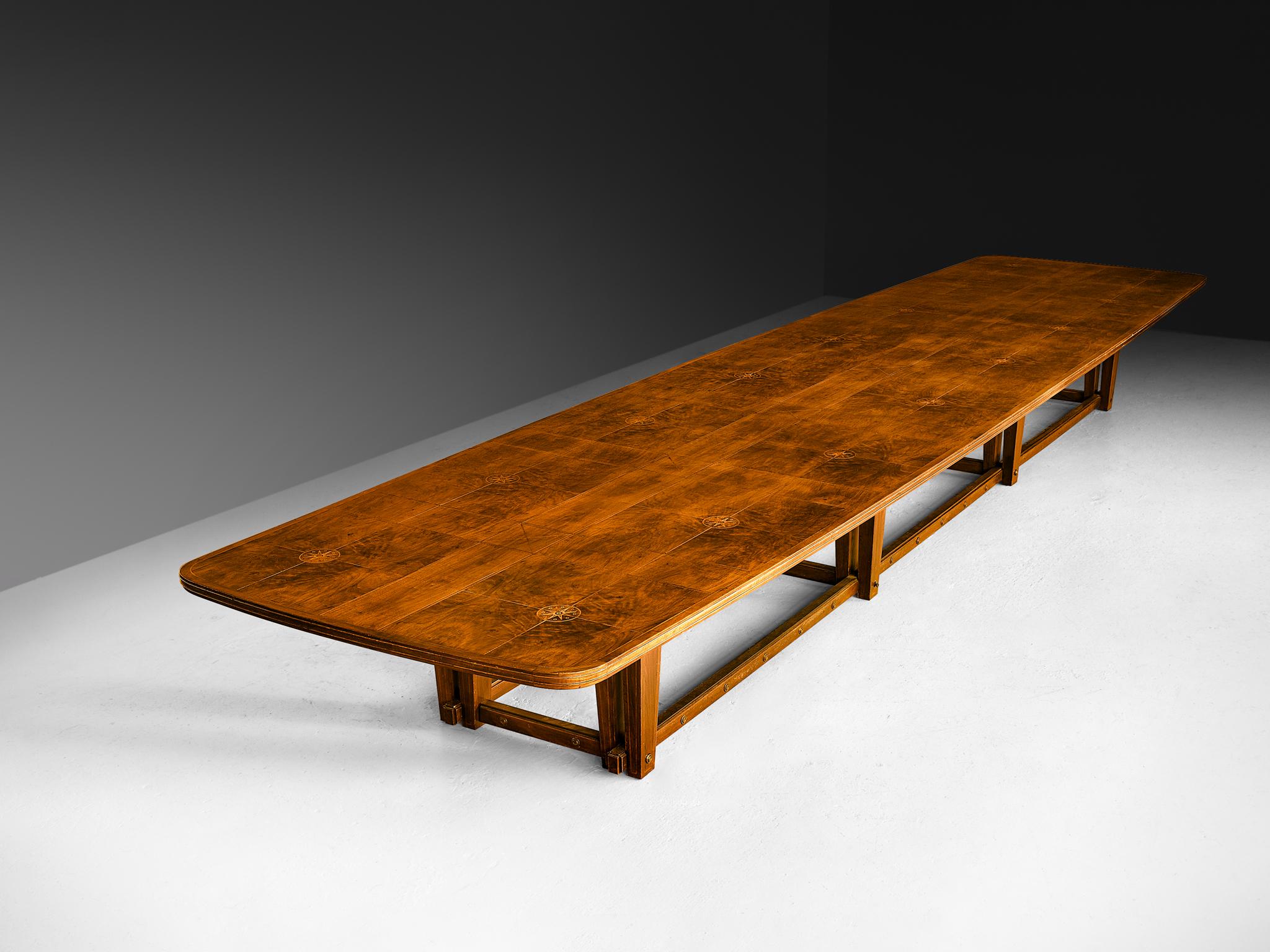 Conference table, walnut, brass, Europe, 1940s

This exquisite conference table, a monumental 23 feet (7.2 meters) in length, is a masterful example of fine woodworking. Crafted from rich walnut, the tabletop features an intricate inlaid design that
