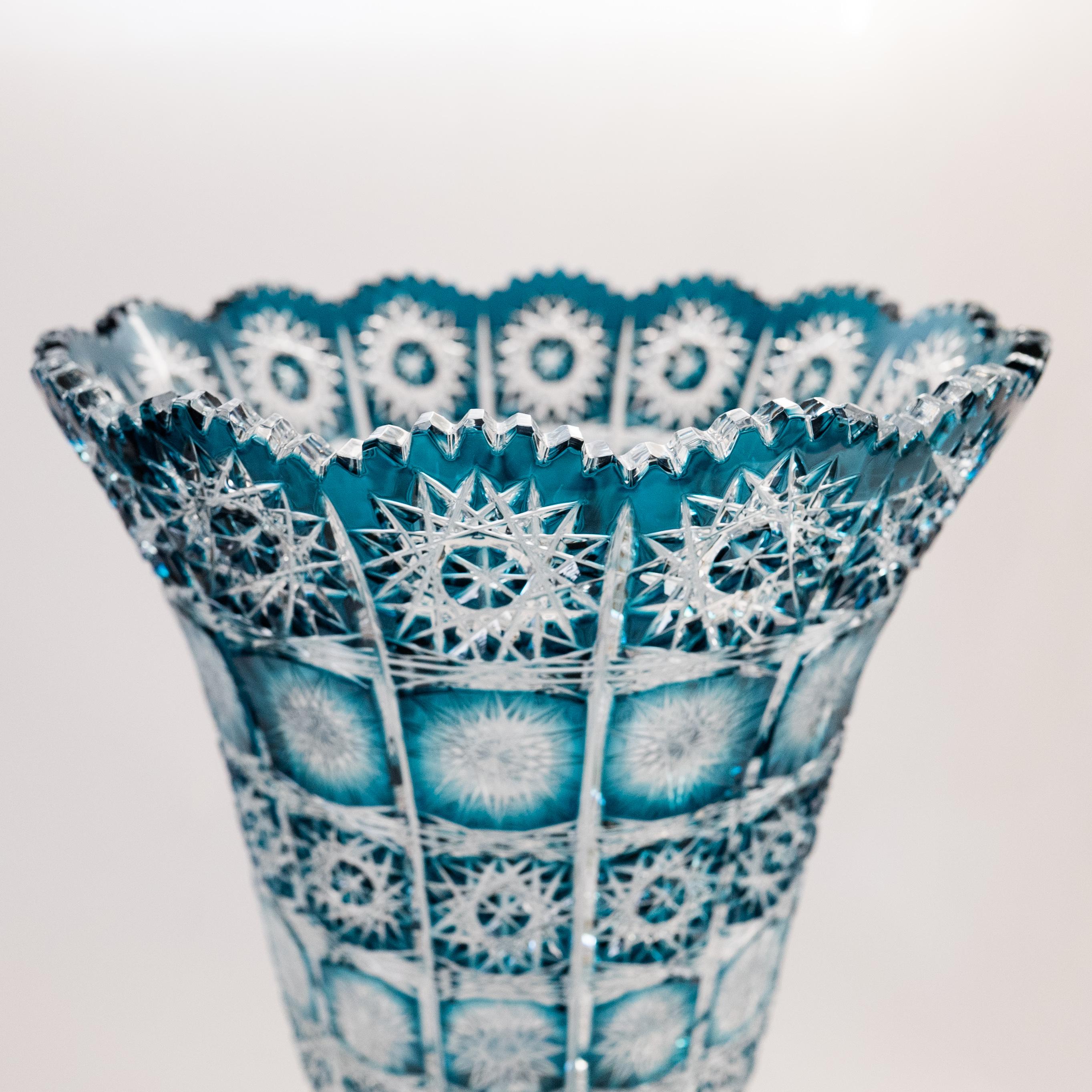 From one of Bohemia's talented art glass companies: Caesar's Crystal, this monumental (and very heavy) crystal vase has been wonderfully and crisply cut in floral and geometric shapes. We love the scalloped shape top and knob stem. The color is