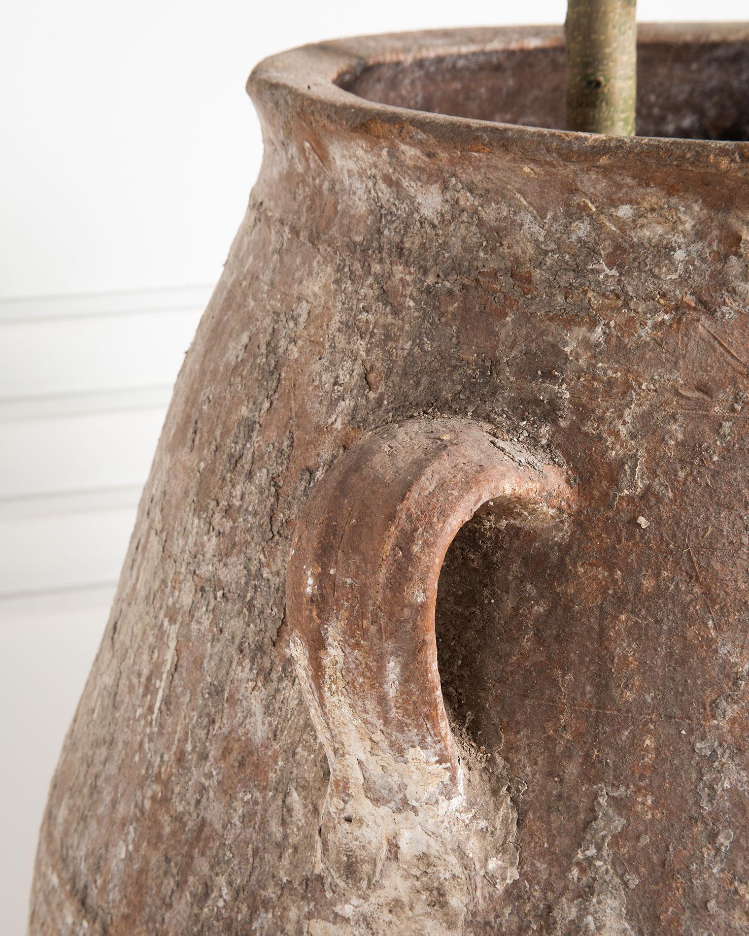 A monumental antique Turkish Olive Jar featuring layers of beautiful patina and age, reflective of its time spent as a utilitarian vessel for the storage of olive oil and olives in the Mediterranean. 

This can be used indoors or outdoors and