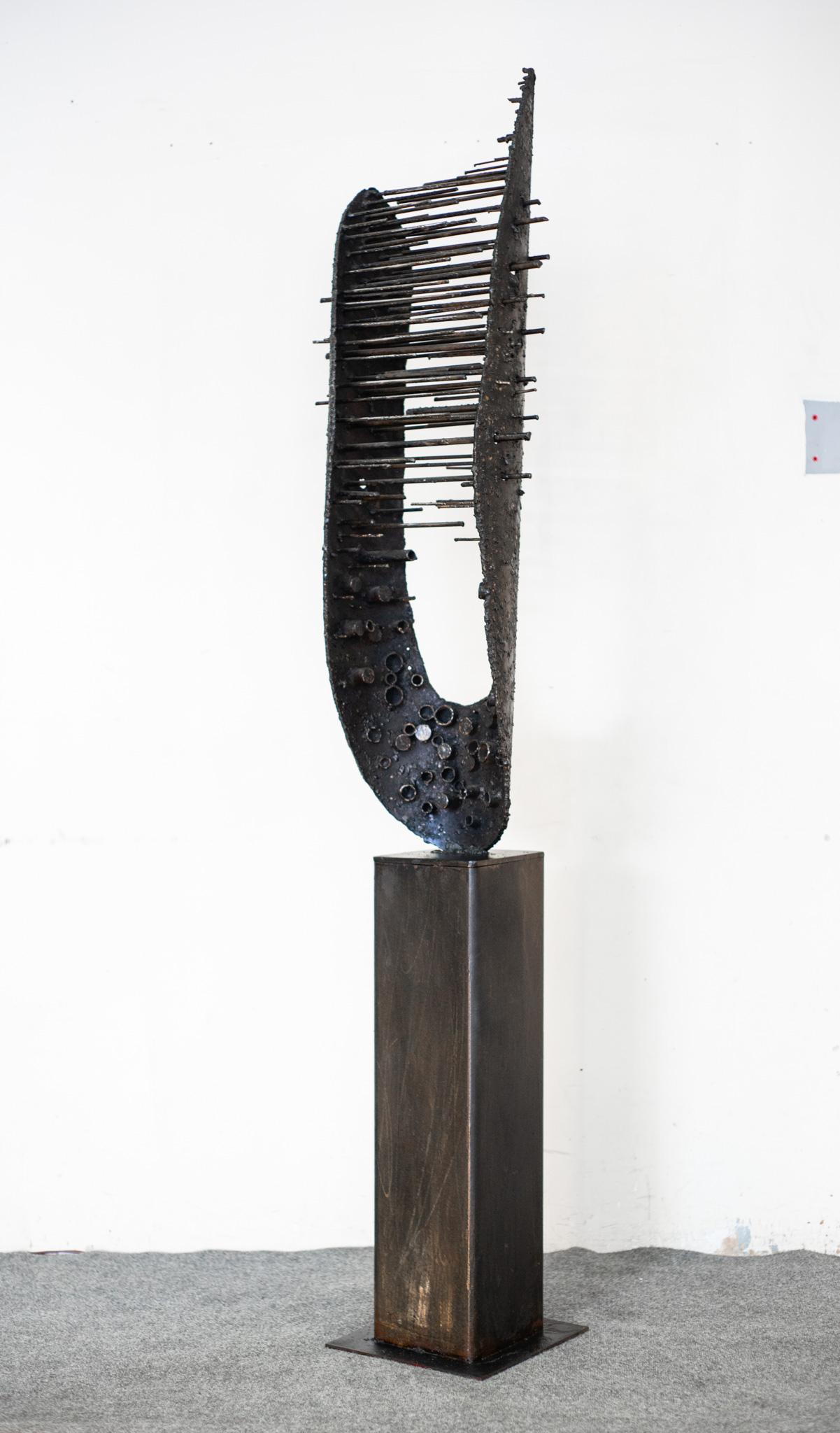 Diseñada y fabricada en Estados Unidos por el artesano estadounidense James Bearden, esta increíble escultura presenta un diseño superfuerte y distintivo. Asentada sobre una gruesa base de columna cuadrada, la escultura forma hasta dos puntas en la