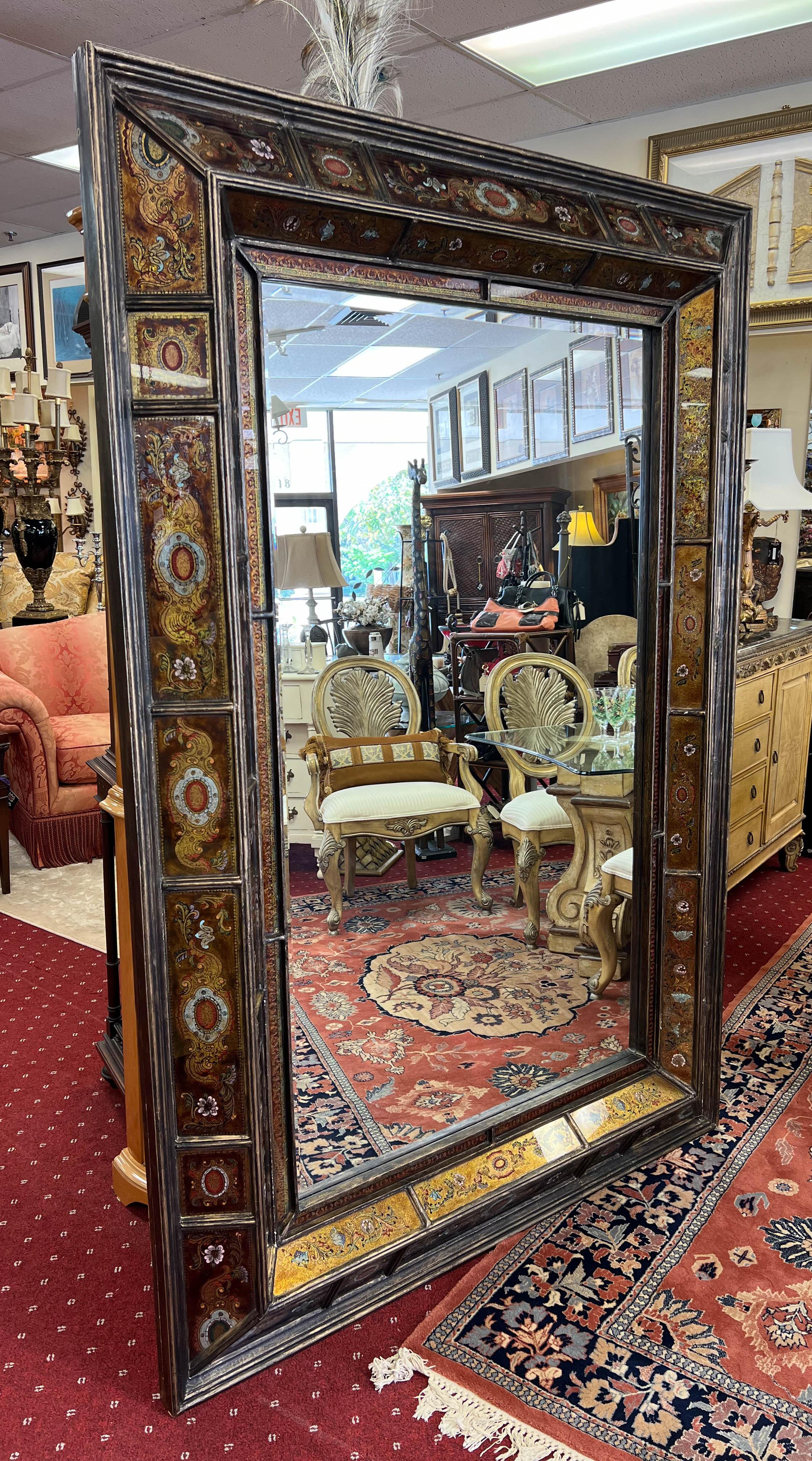  A sizable rectangular mirror featuring a captivating art form known as reverse glass painting or verre églomisé. 

The reverse glass painting technique in this mirror is a true art form requiring precision and expertise. The artist carefully