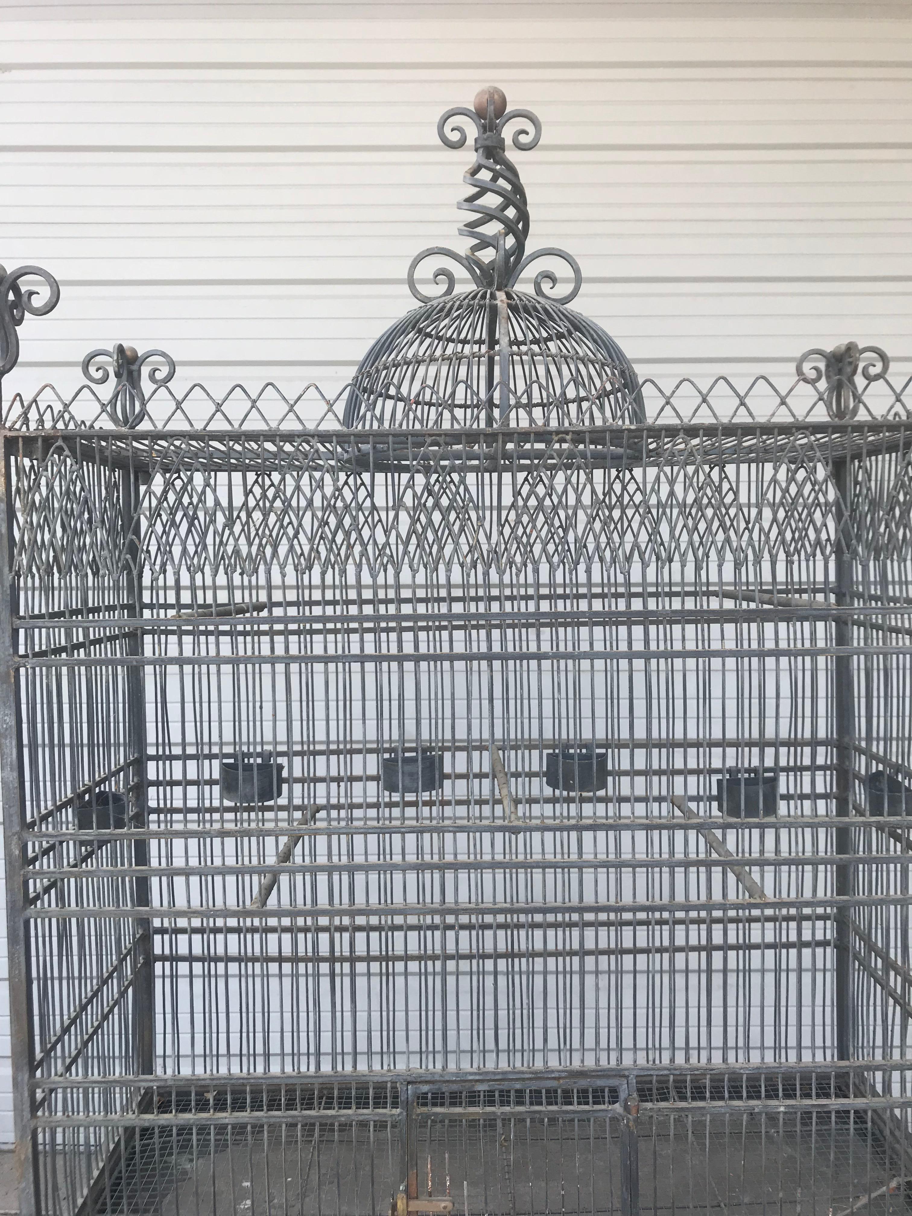 Monumental Victorian style antique brass, painted bird iron bird cage, having a stand that is 33 inches in height this palatial birdcage is constructed of ebony painted iron finish and brass. And is certain to add conversation as well as a fine home