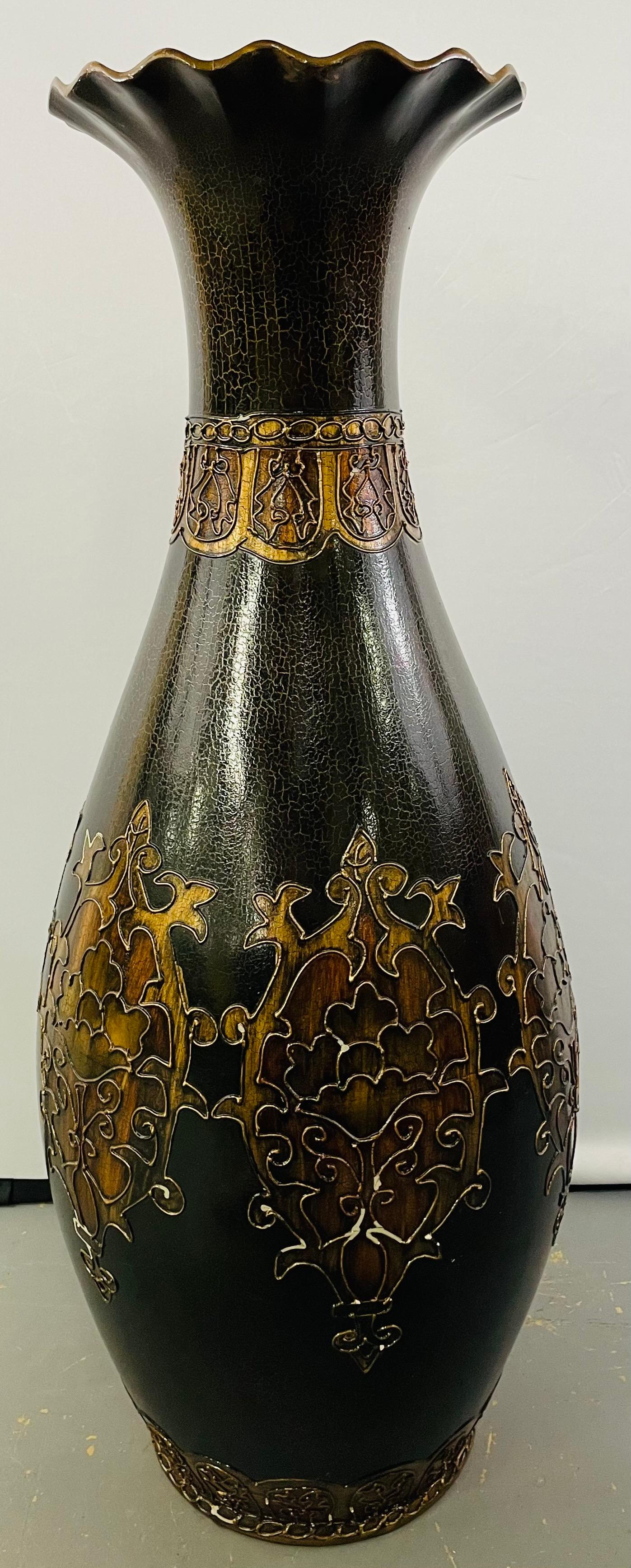 A monumental Art Nouveau Black and Gold  enameled vase featuring fine floral etching design painted in an antiqued gold tone color around the body and the neck of the vase. The vase shows a natural craquelure on the paint as a result of aging which