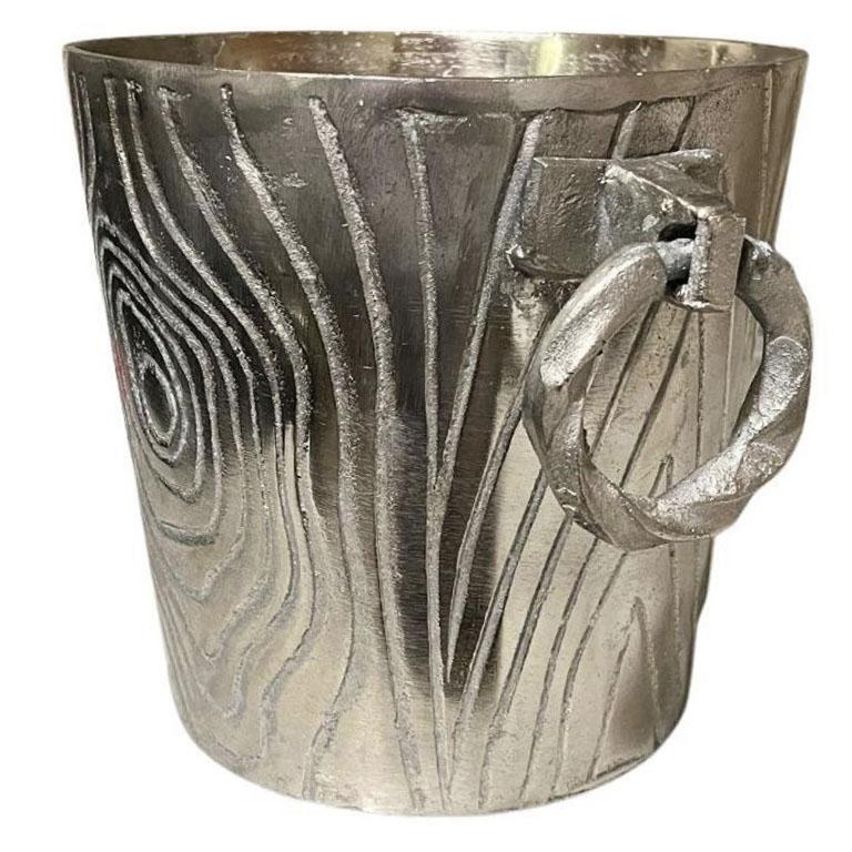 A large faux bois metal ice bucket with twisted metal handles. A gorgeous vintage piece that will be fabulous on a bar or coffee table at your next cocktail party. The piece is in a silver hue metal with a lovely wood grain look carved into the