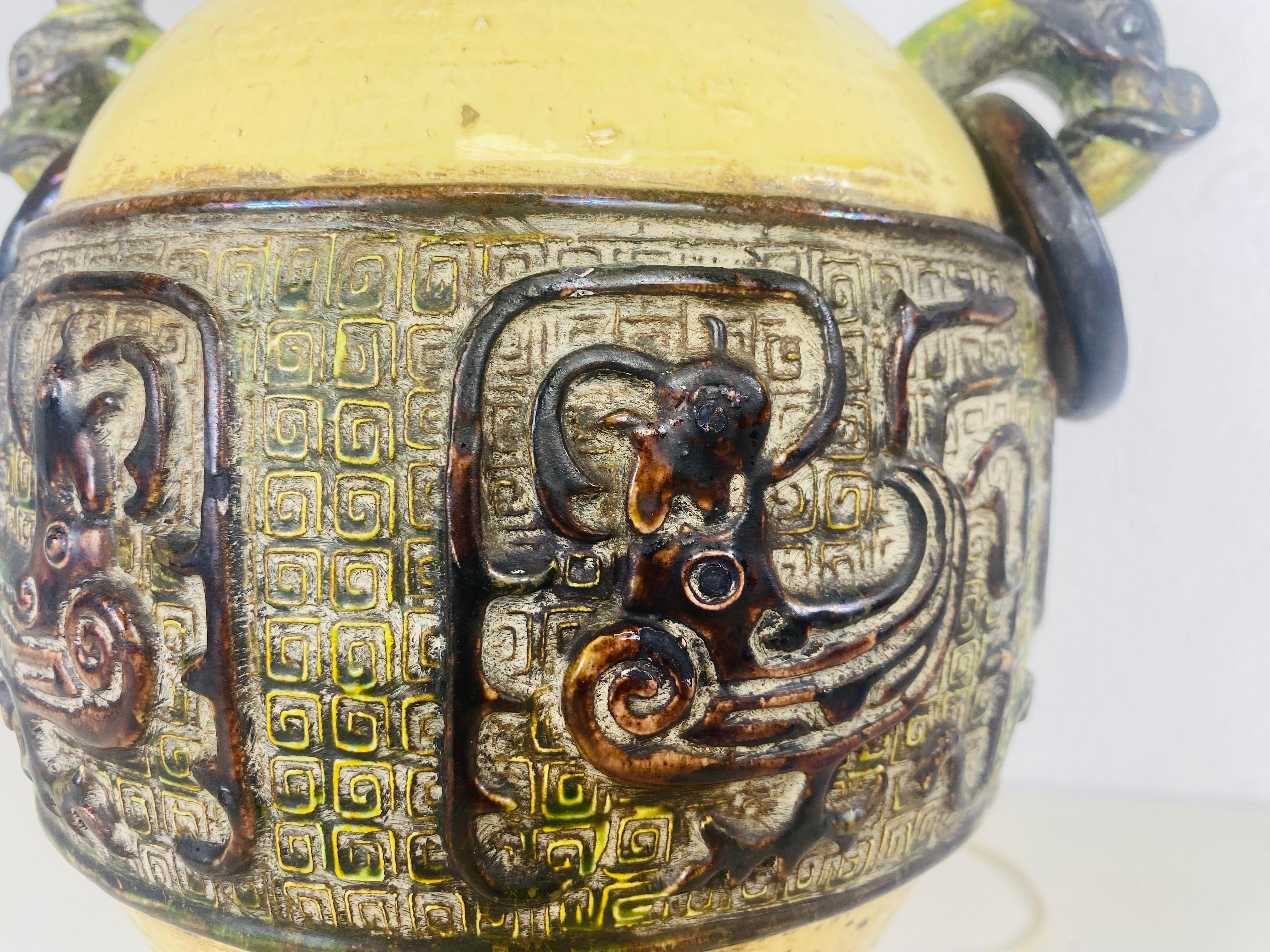 Voici une lampe de table en poterie d'inspiration asiatique du milieu du siècle dernier. Cette lampe est dotée d'un abat-jour en papier Silverleaf d'origine. Cette lampe présente une décoration ornementale d'inspiration asiatique sur toute sa