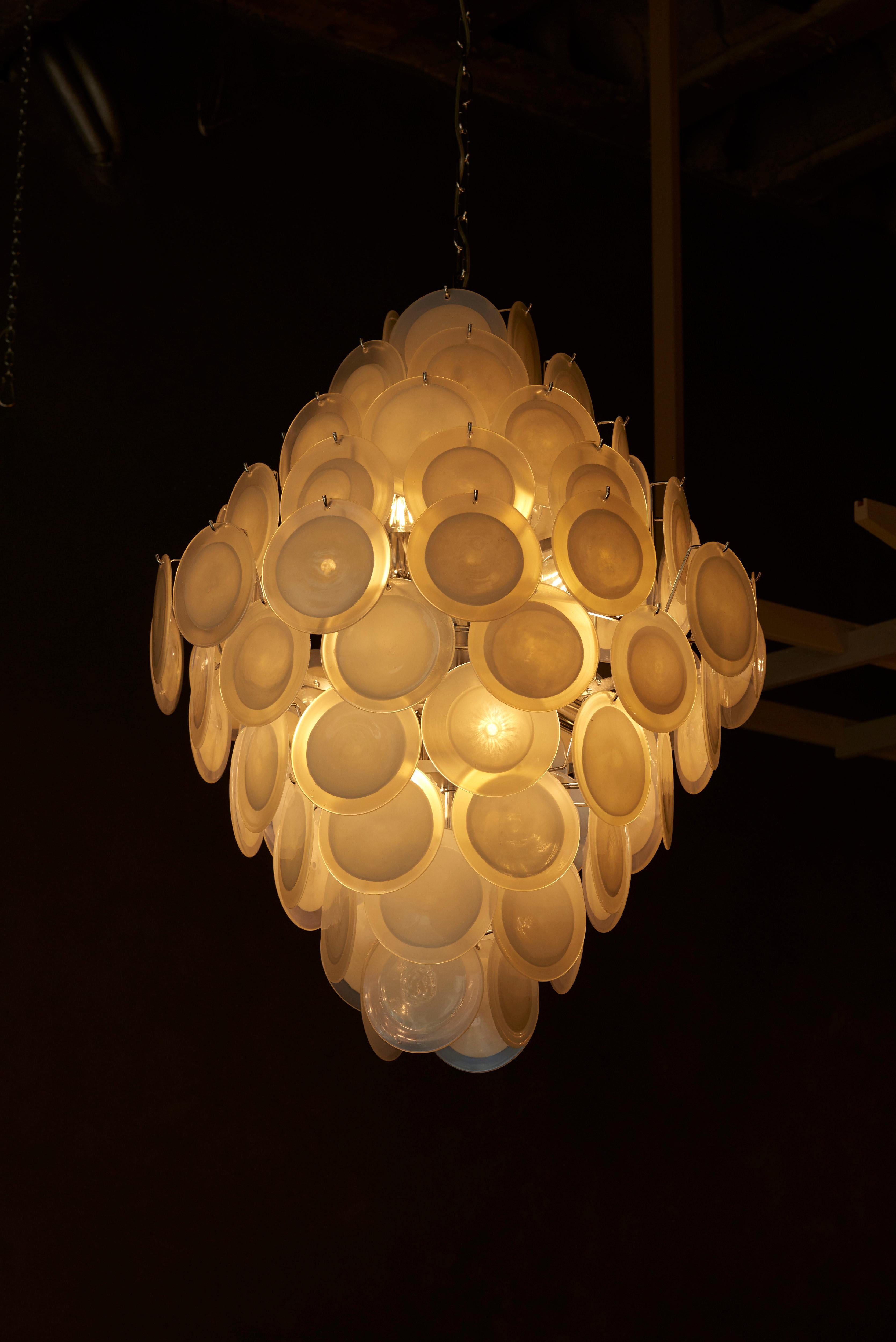 Monumental large white iridescent Murano glass disc chandelier attributed to Vistosi.
The chandelier is a perfect eyecatcher in every room. 10 x E27 bulbs.

To be on the safe side, the lamp should be checked locally by a specialist concerning