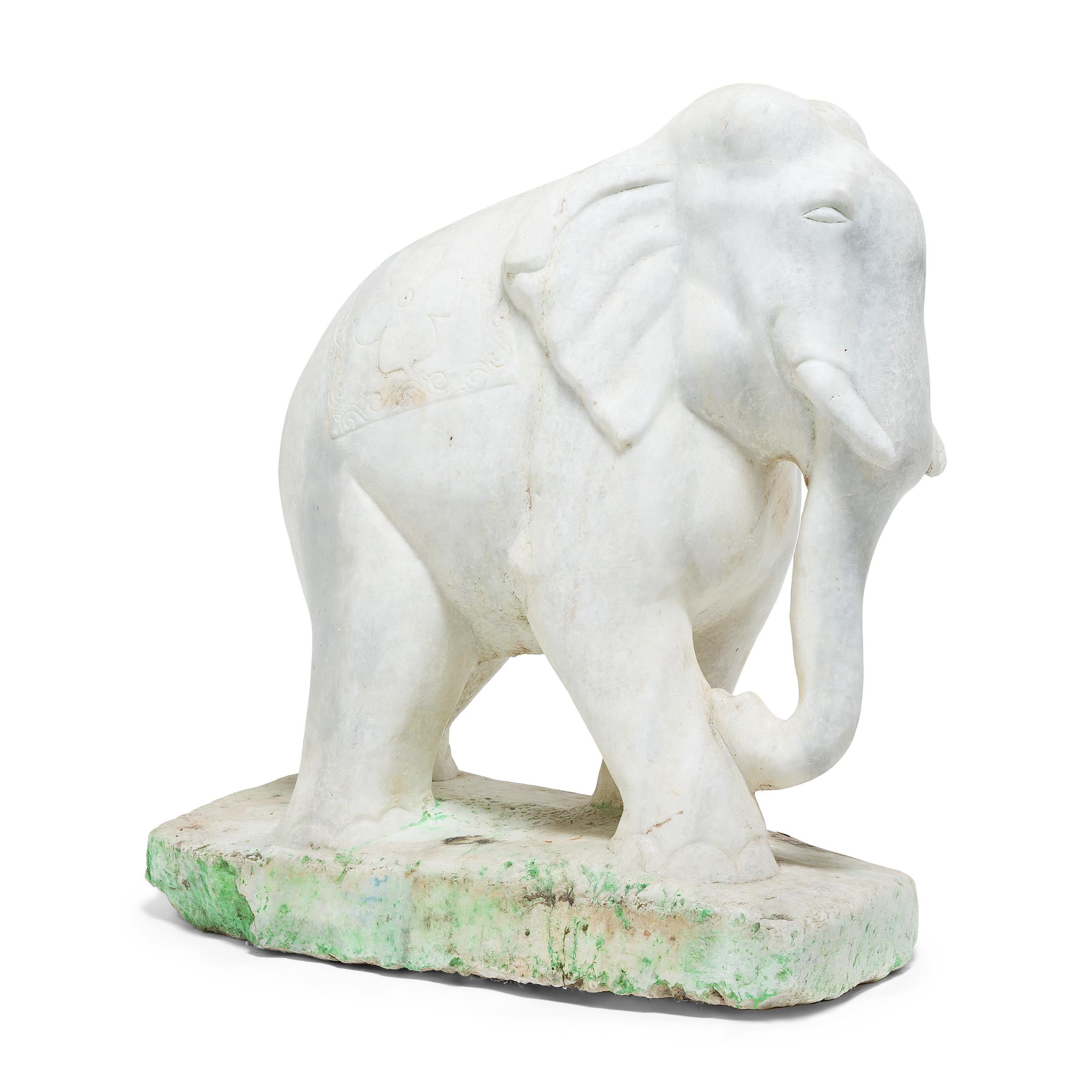 This impressive Thai elephant sculpture was carved mid-stride from a solid block of white marble. A symbol of strength, loyalty, and longevity, the elephant holds great cultural significance in Thailand and today reigns as the country's national