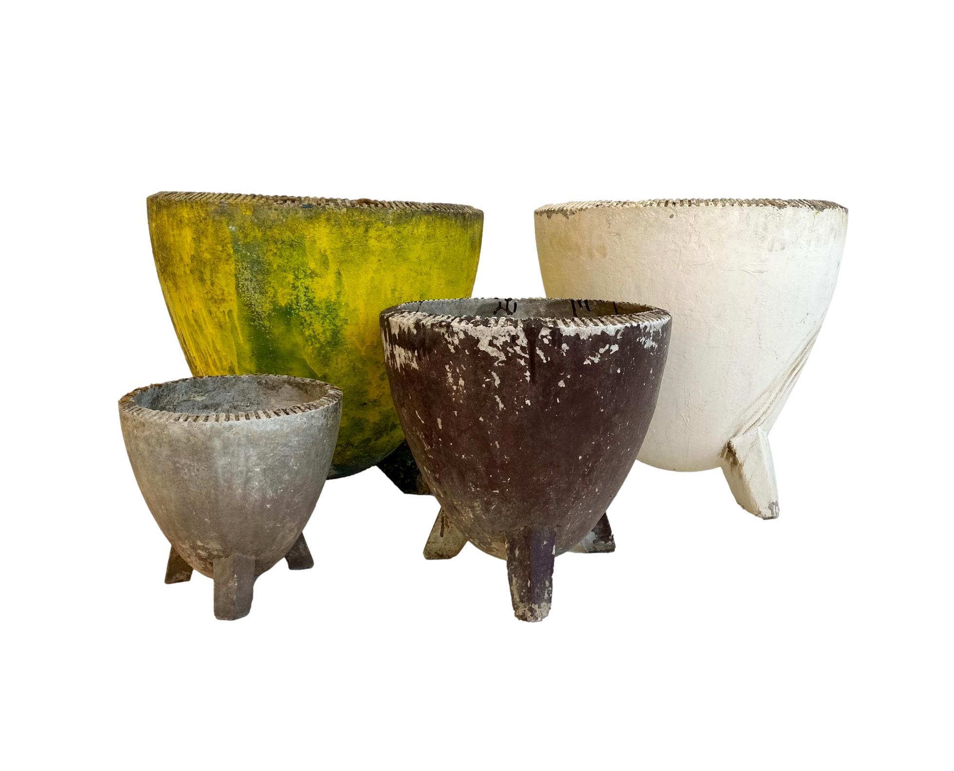 Gigantic concrete planters by Willy Guhl for Eternit. Heightened bowl with a three legged base. Teeth ridges along the upper rim. Great patina and condition. Factory markings. Super unique shape. Four available. Priced individually. 

   