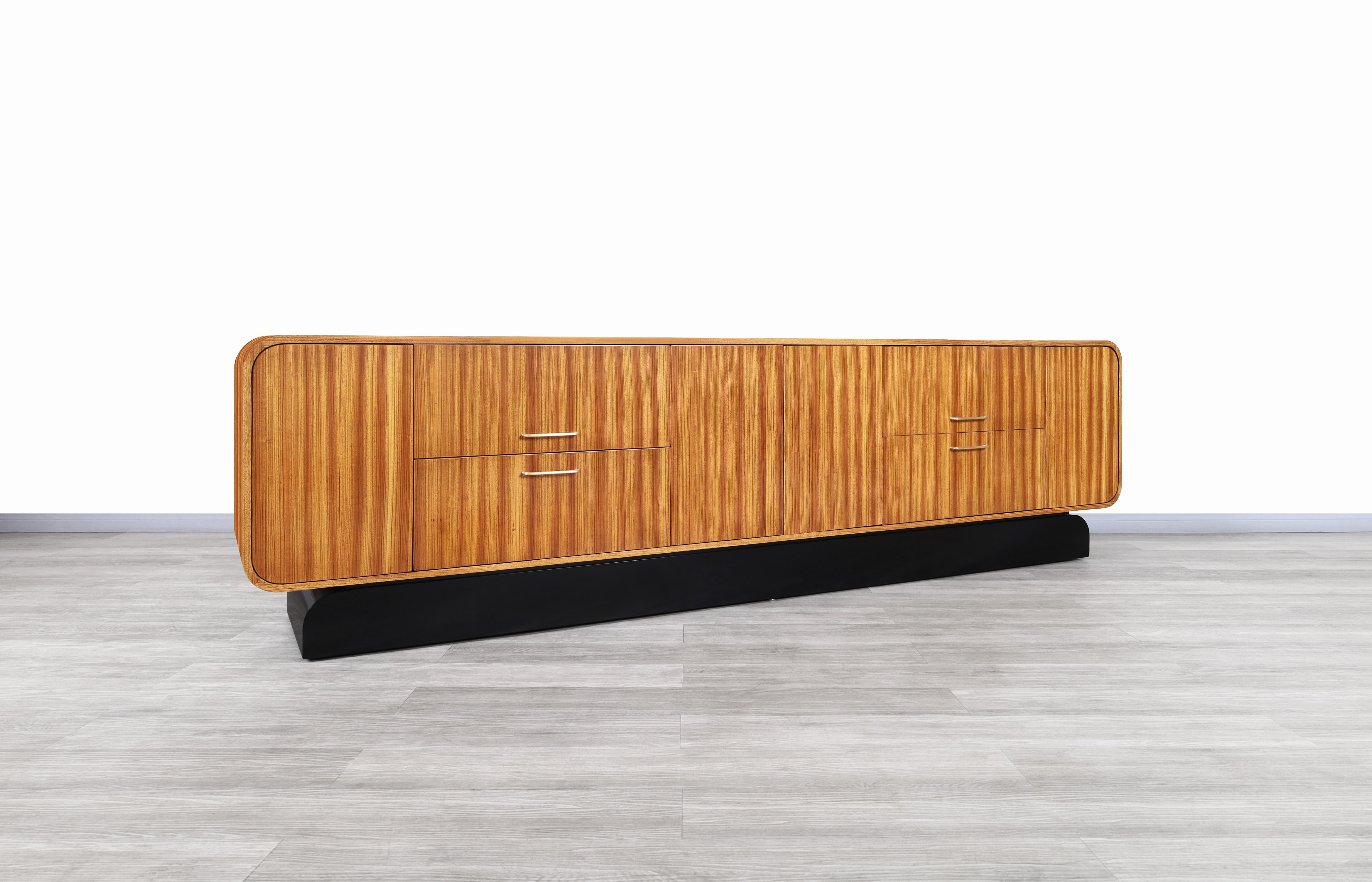 Vintage monumental zebra wood credenza designed and manufactured in the United States, circa 1980s. This credenza stands out for the exquisite design that is represented through its unique curves. It's complemented by the elegant contrast of colors