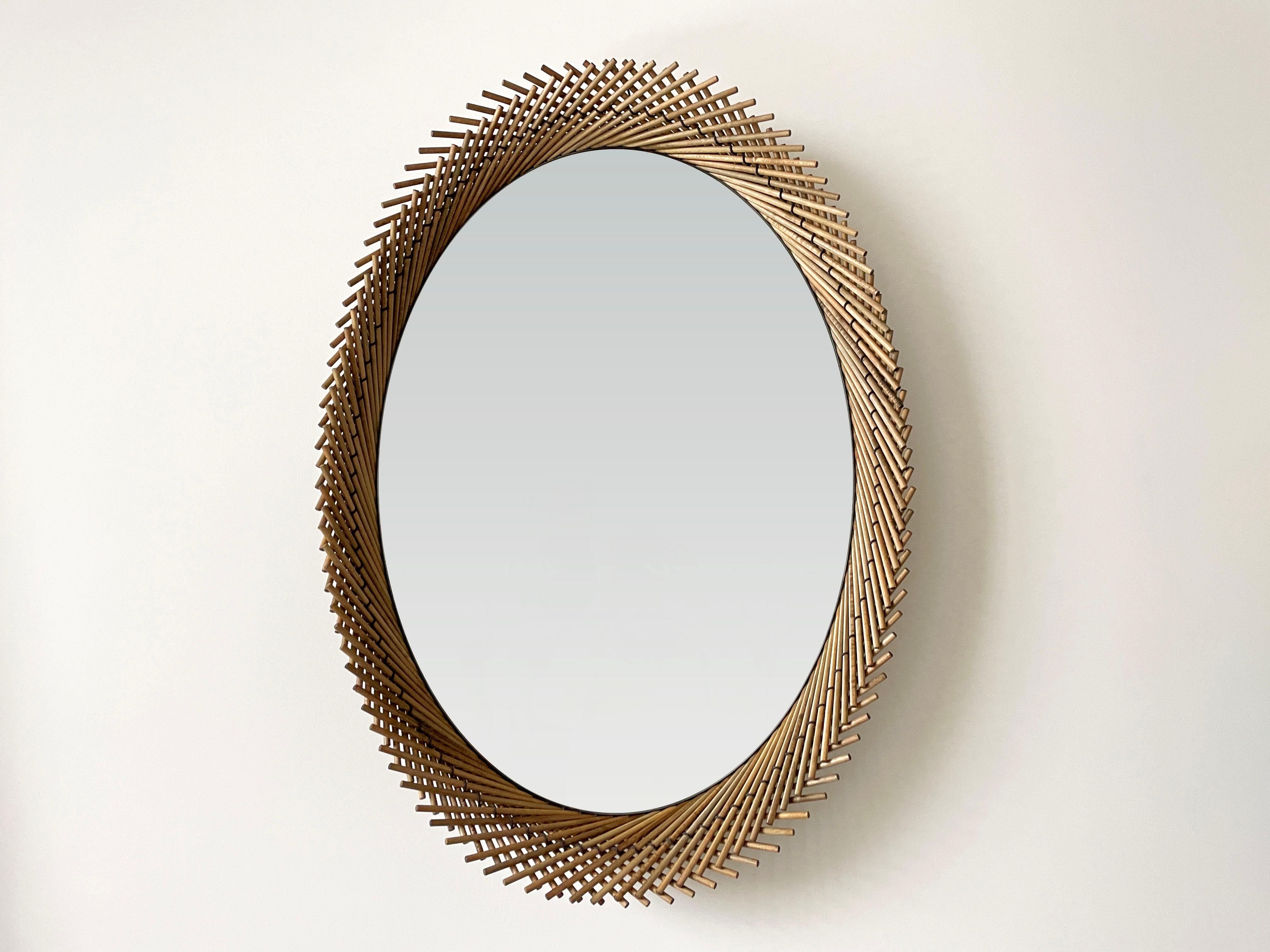 The Oval Mirror pushes the strict geometry that occurs as a result of stitching the dowels together to create a dynamic edge. Each layer of the Mooda rises and falls inversely to the other as they travel along the circumference of the mirror, giving