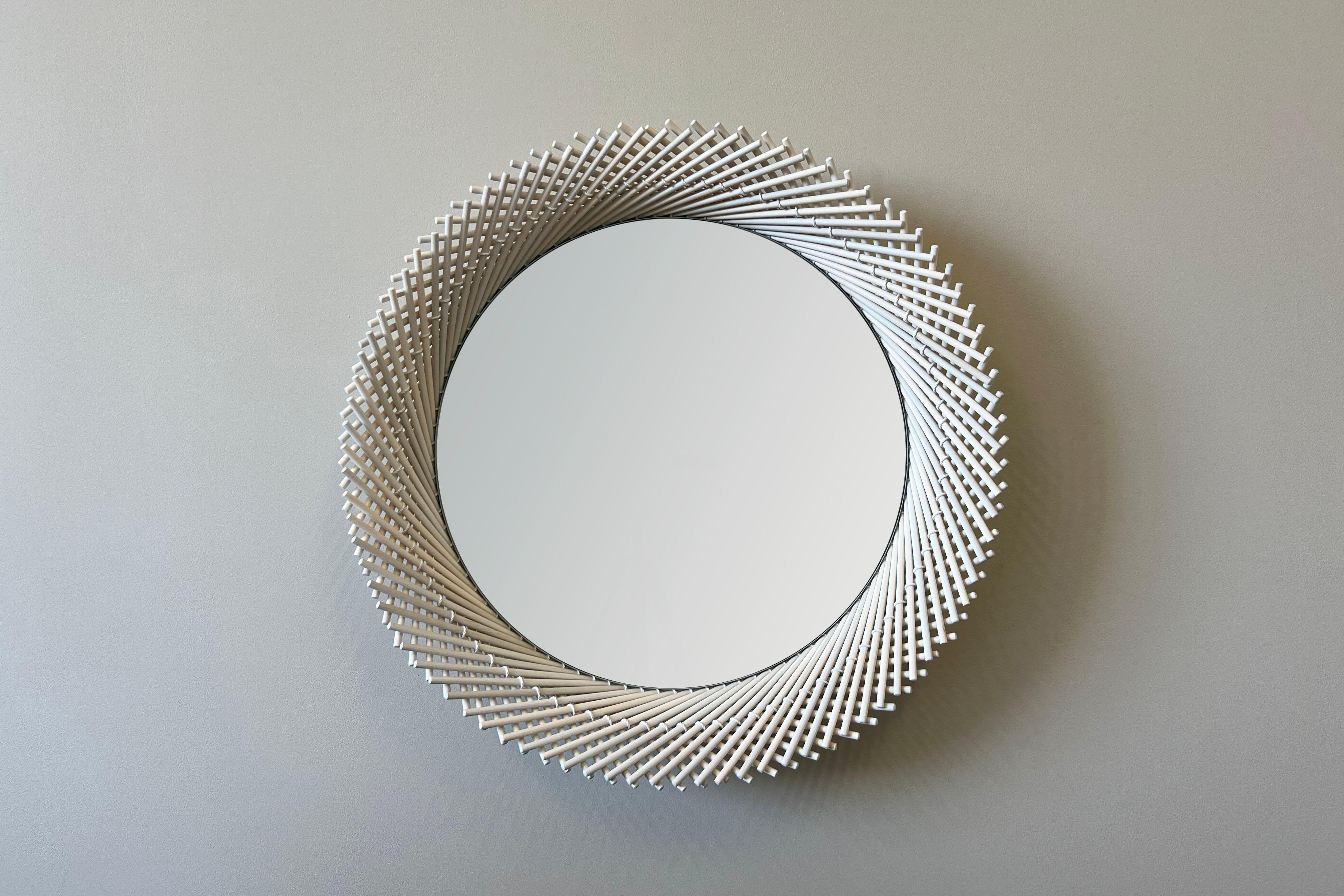 The Mooda mirror is composed of a set of dowels stitched together to create a beautiful geometric edge around the glass. The mirror in turn reflects the dowels along its circumference, completing the traditional form of the Mooda. 

Available in two