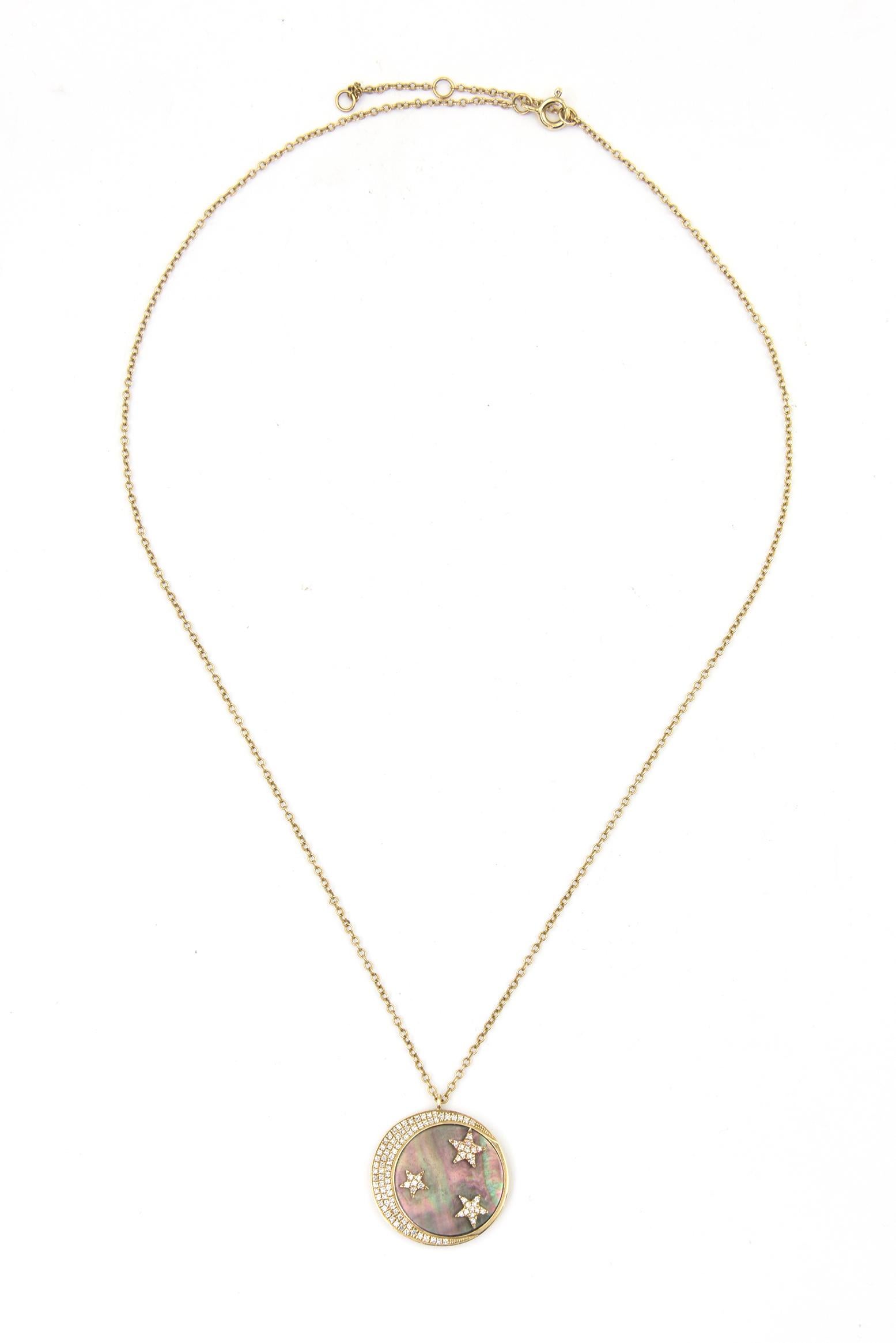 Ce pendentif captivant du XXIe siècle présente un design céleste avec un croissant de lune et trois motifs d'étoiles, chacun incrusté de diamants blancs ronds totalisant 0,40 carat. Les étoiles et la lune reposent sur un fond de nacre chatoyant,
